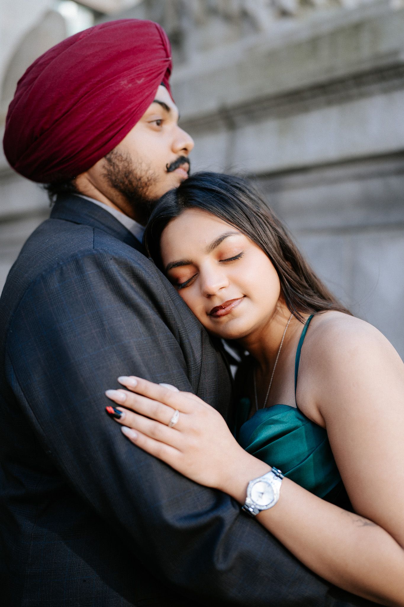 A couple shares an intimate embrace while wearing traditional Sikh attire and western clothing in a romantic photoshoot.
