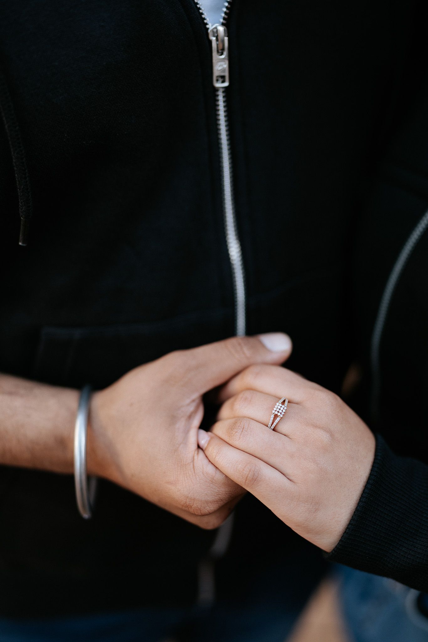 Close-up sequence showing hands with an engagement ring in dim lighting.