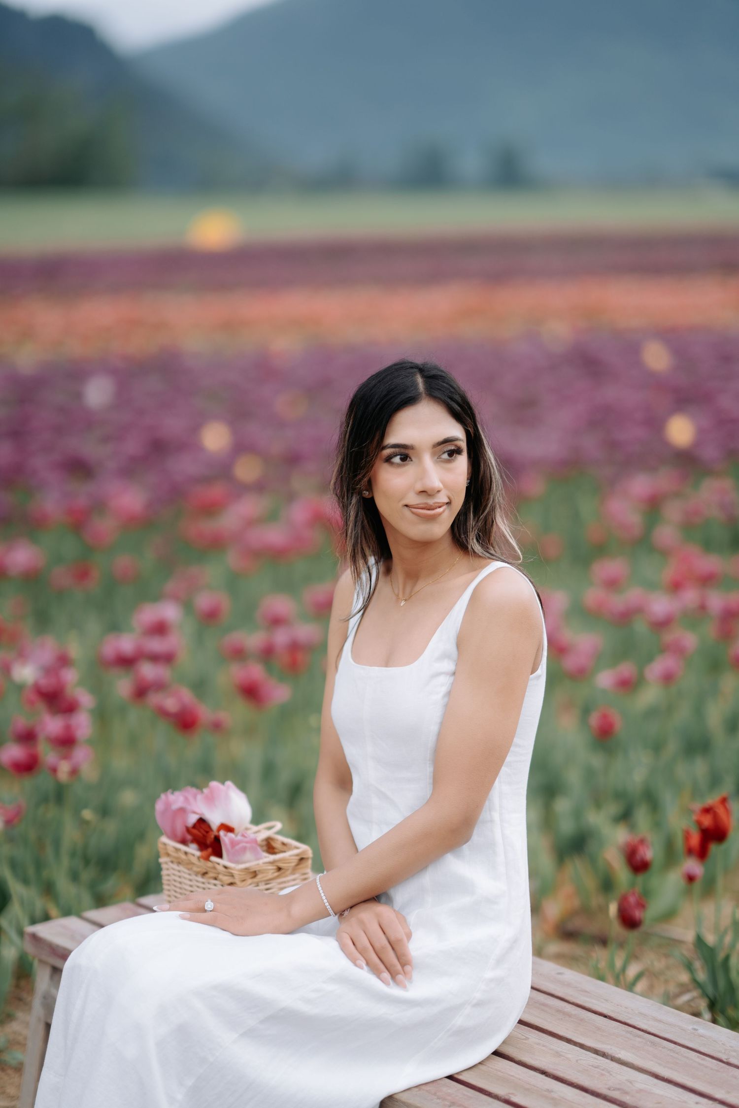 A series of photos showing someone in a white dress sitting on wooden decking beside a field of red poppies.