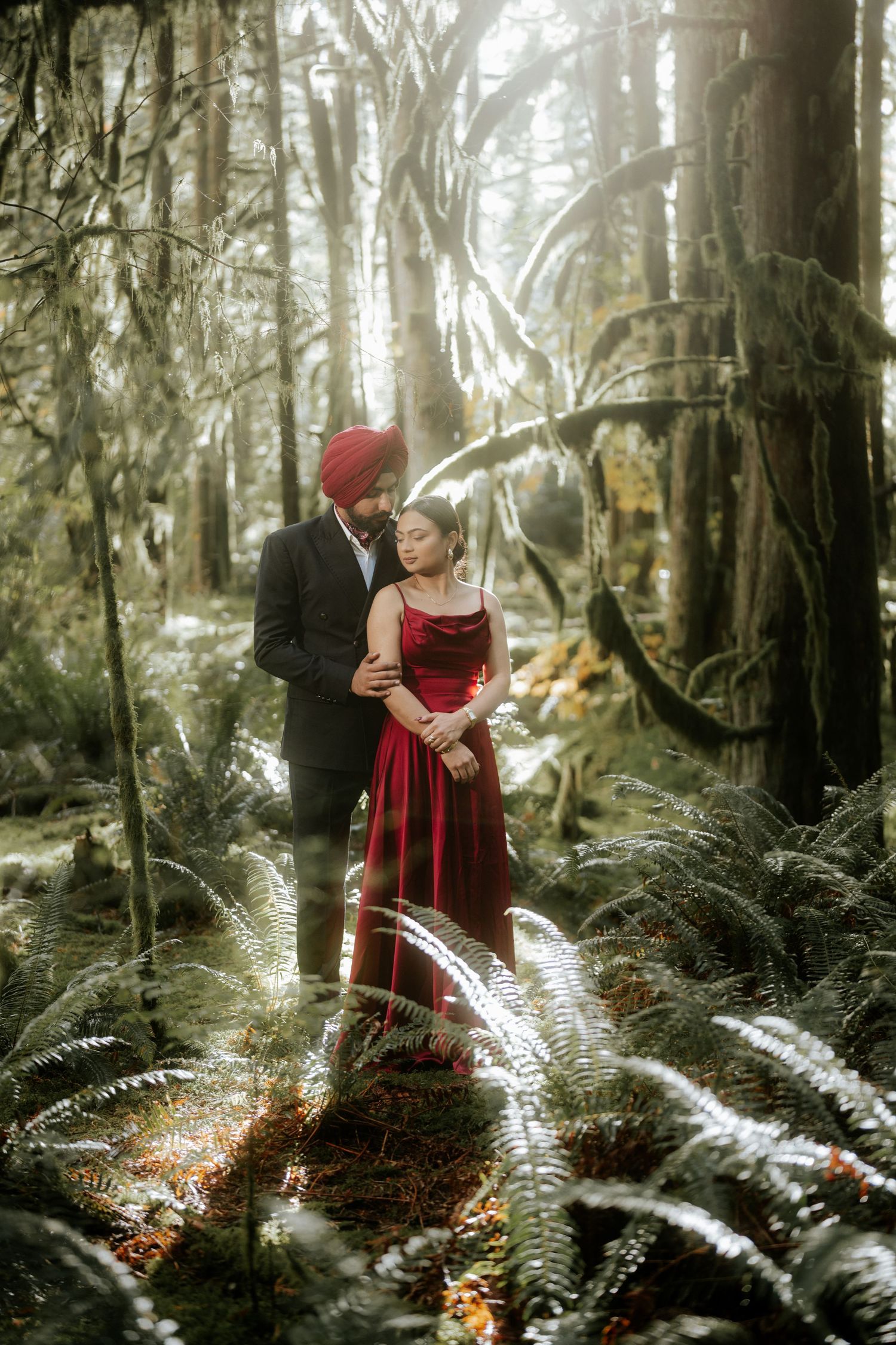 Sunlit forest scene with red dress creating dramatic contrast among tall trees.