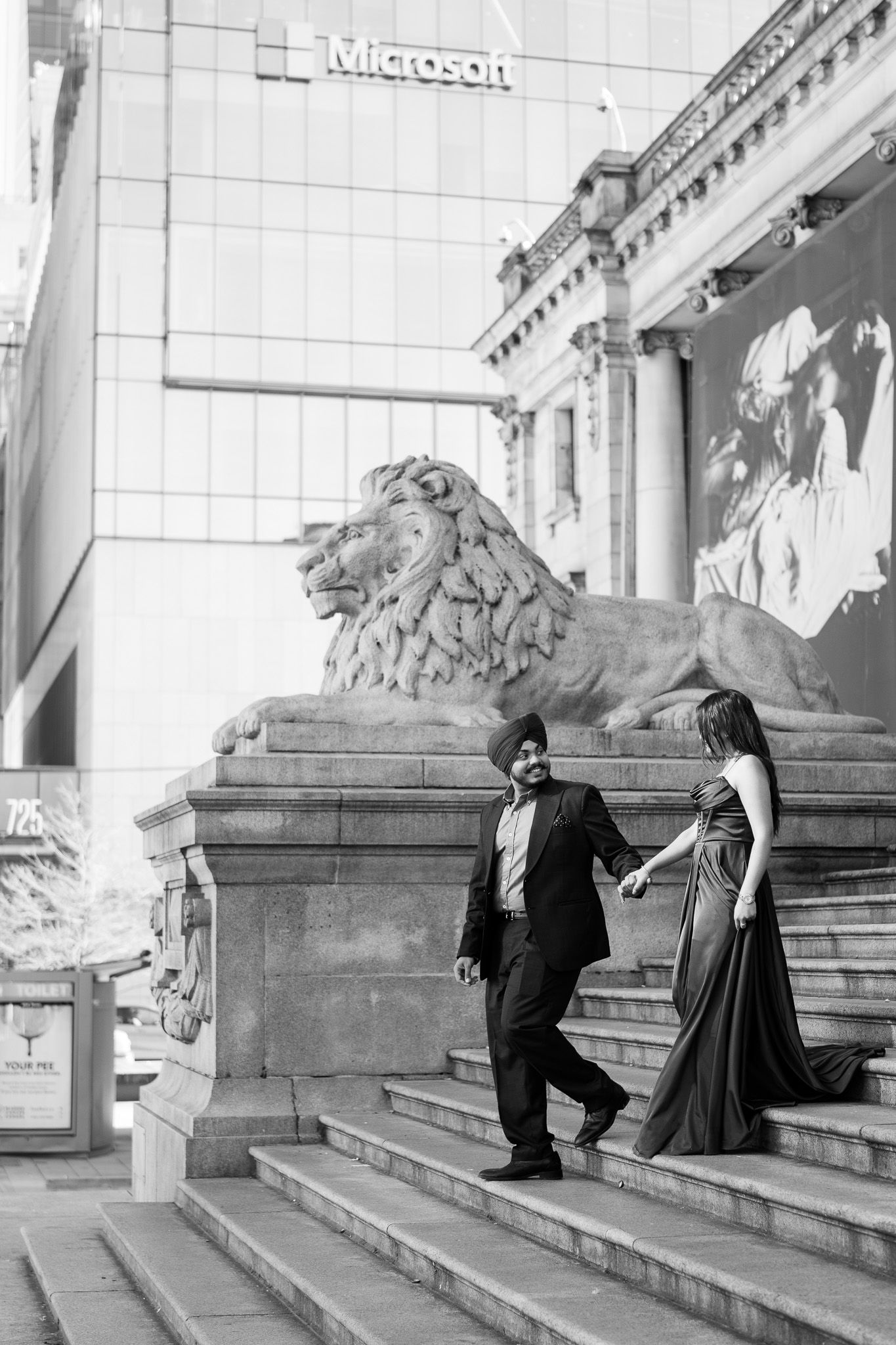 A series of black and white photos showing two people playfully posing on stone steps outside a grand building.