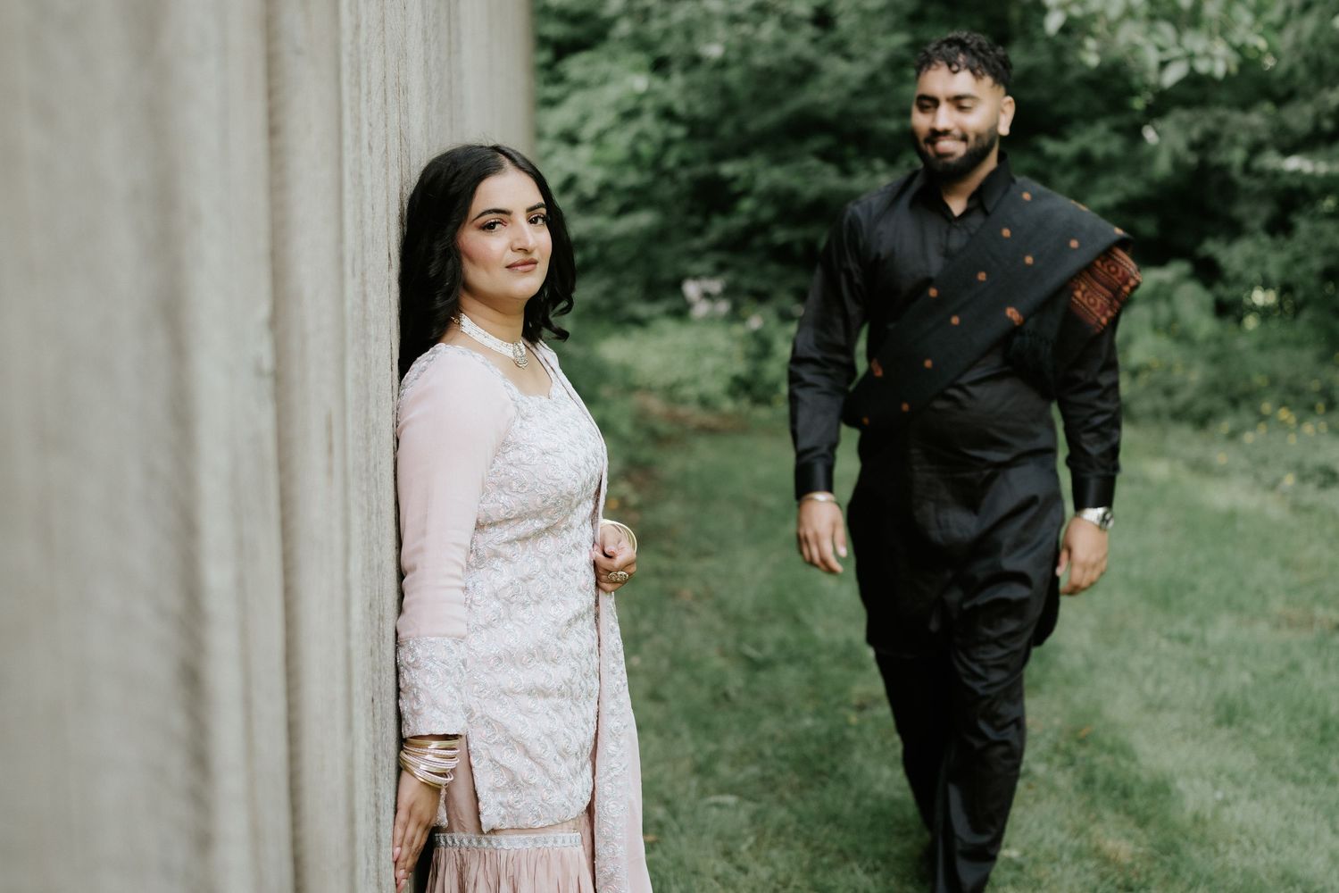 Romantic outdoor photoshoot featuring traditional attire against a rustic backdrop.