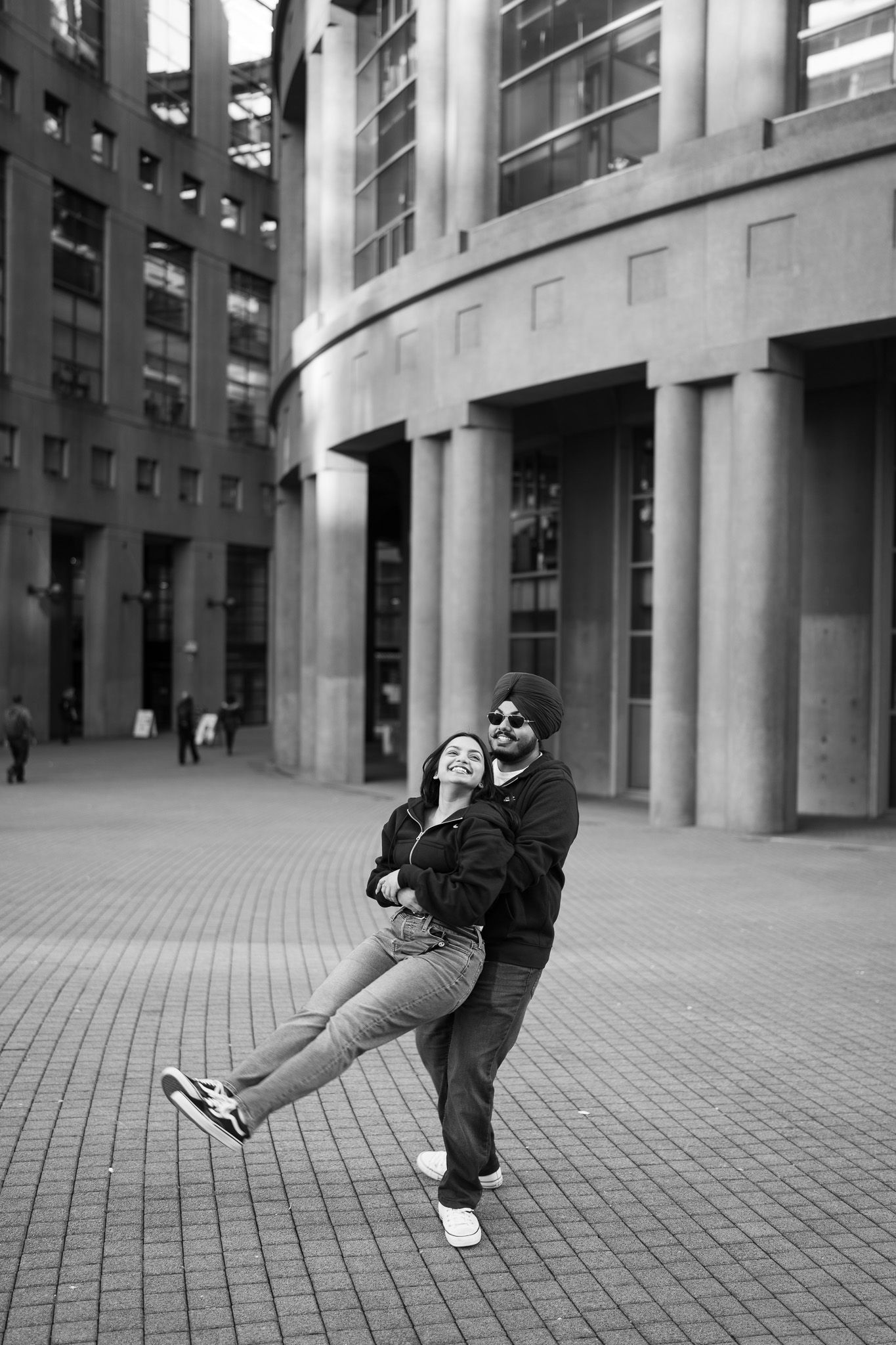A sequence of black and white photos showing a person leaning backwards against a modern urban building facade.