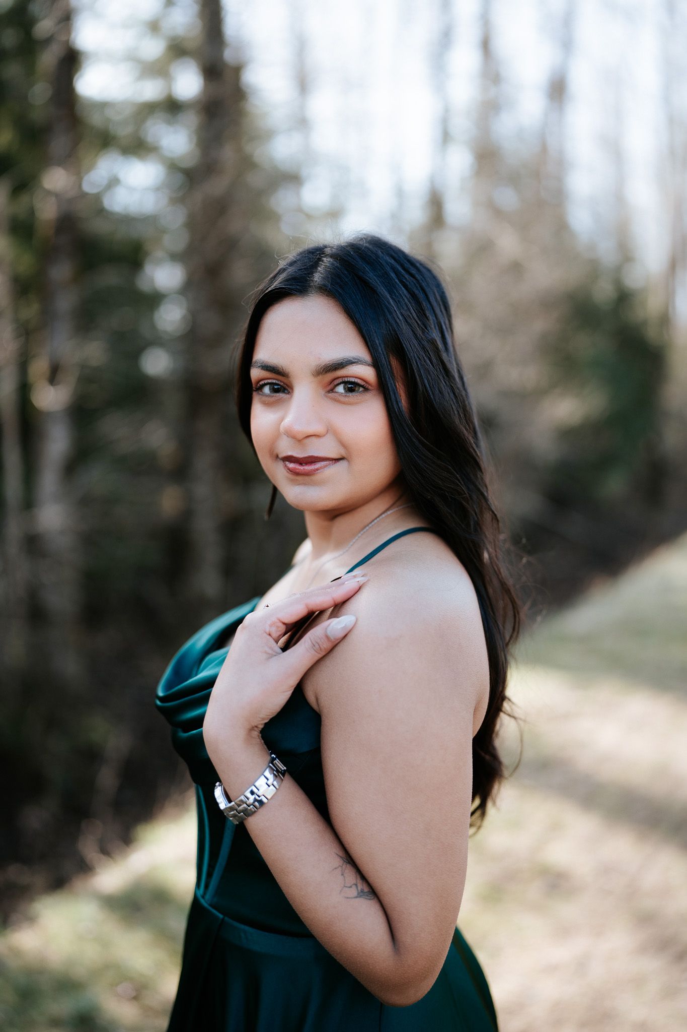 A series of outdoor portrait shots showing a woman in a dark dress posing against a natural forest backdrop.