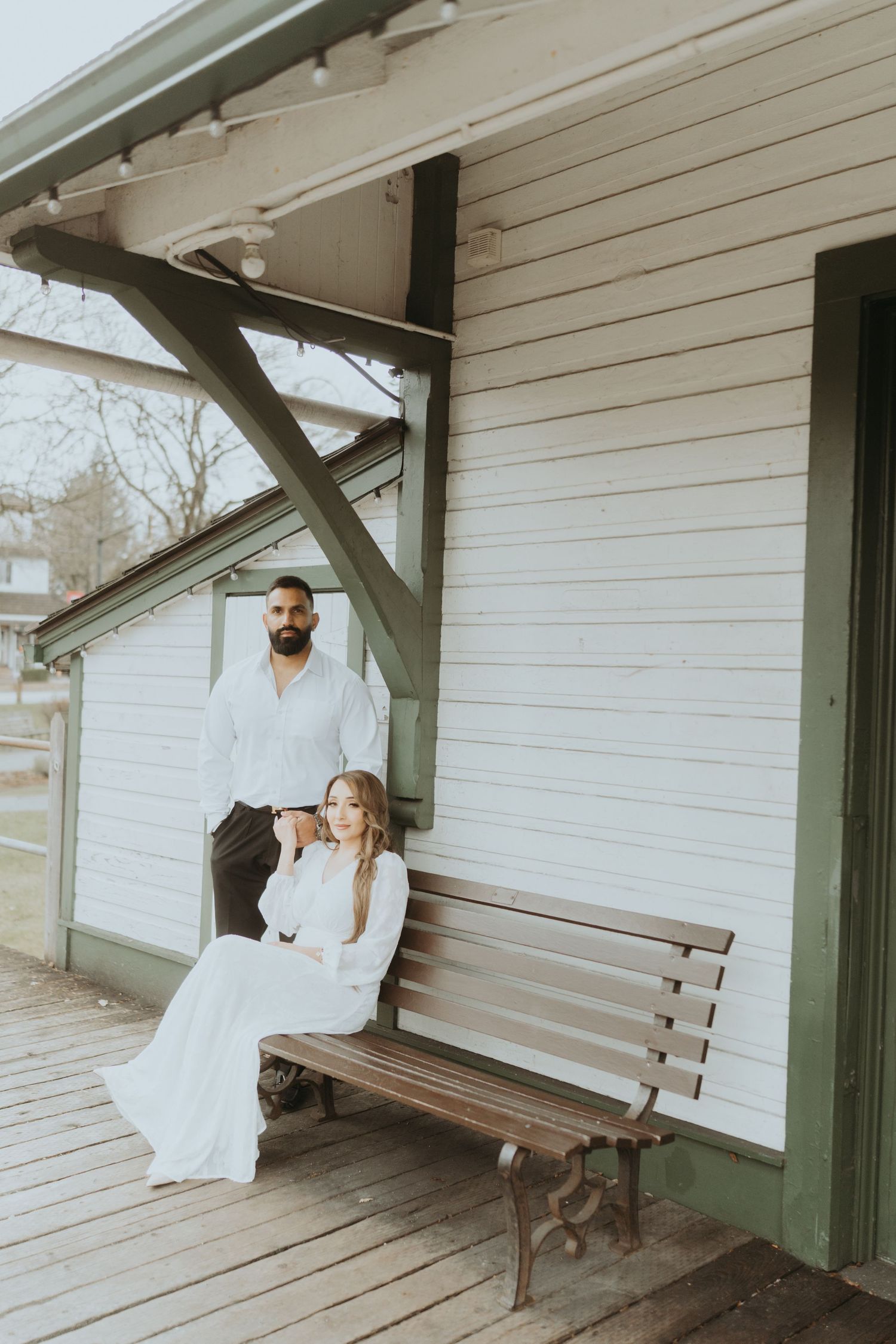 Wedding photo series on a covered wooden platform at a historic train station.