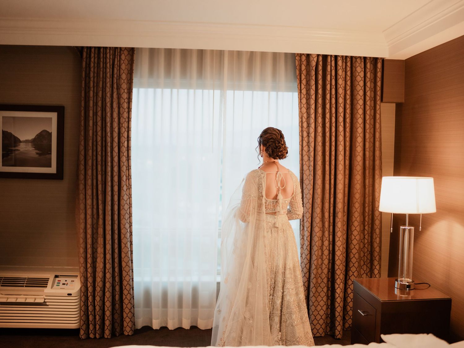 Interior hotel room scene with brown curtains and soft lighting creating romantic ambiance.
