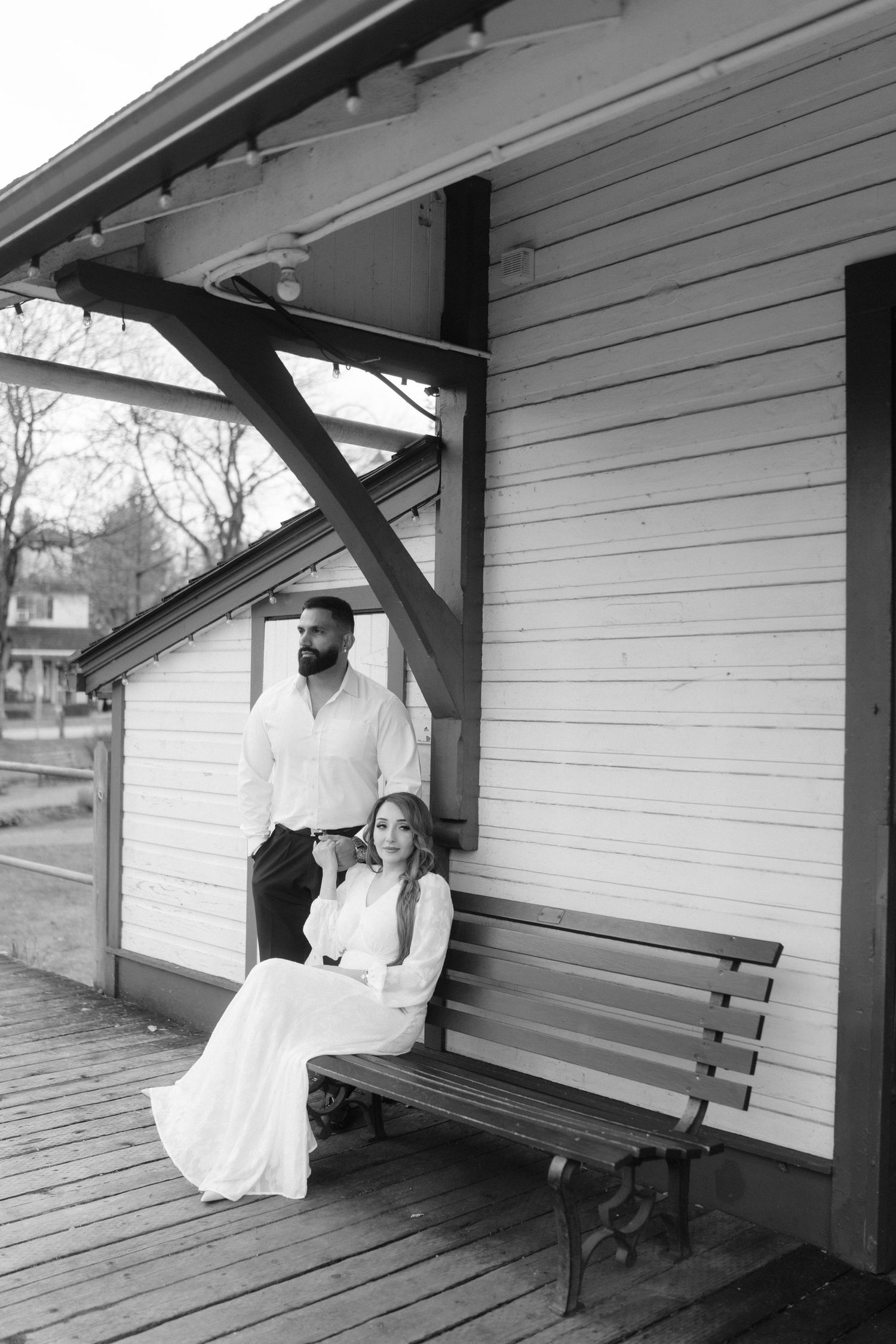 Black and white wedding photographs on a historic train station platform.