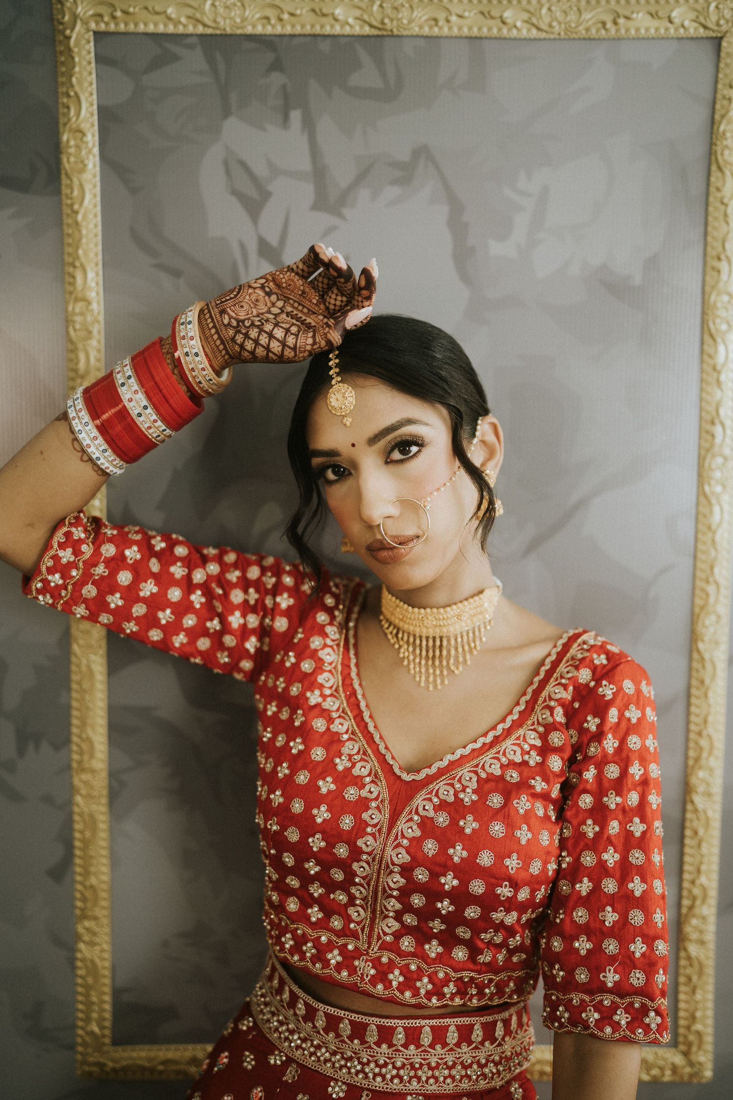 Close-up shots of traditional Indian bridal attire featuring red and gold embroidered details.