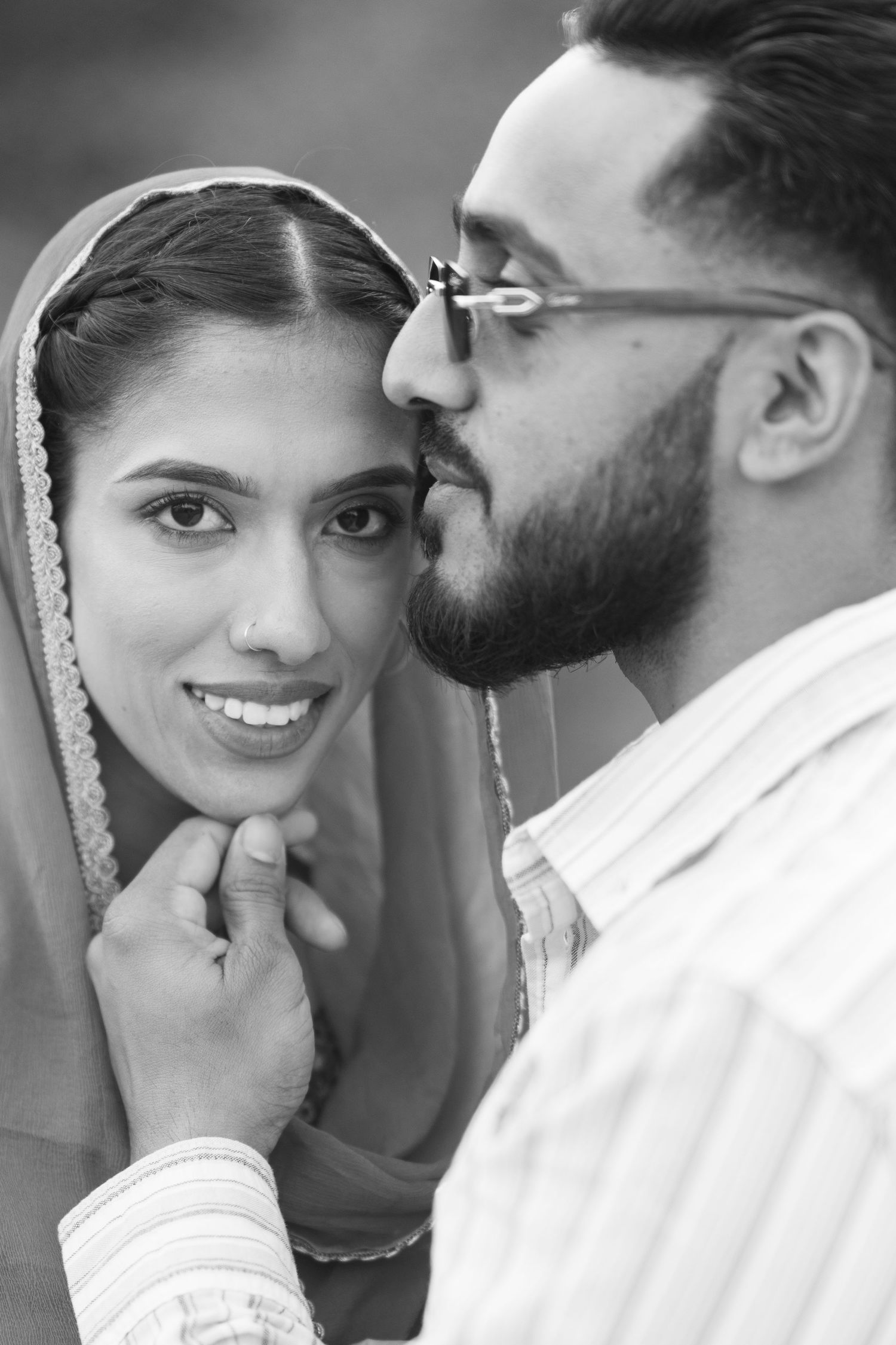 A romantic black and white photo collage showing tender moments between a couple in traditional South Asian wedding attire.