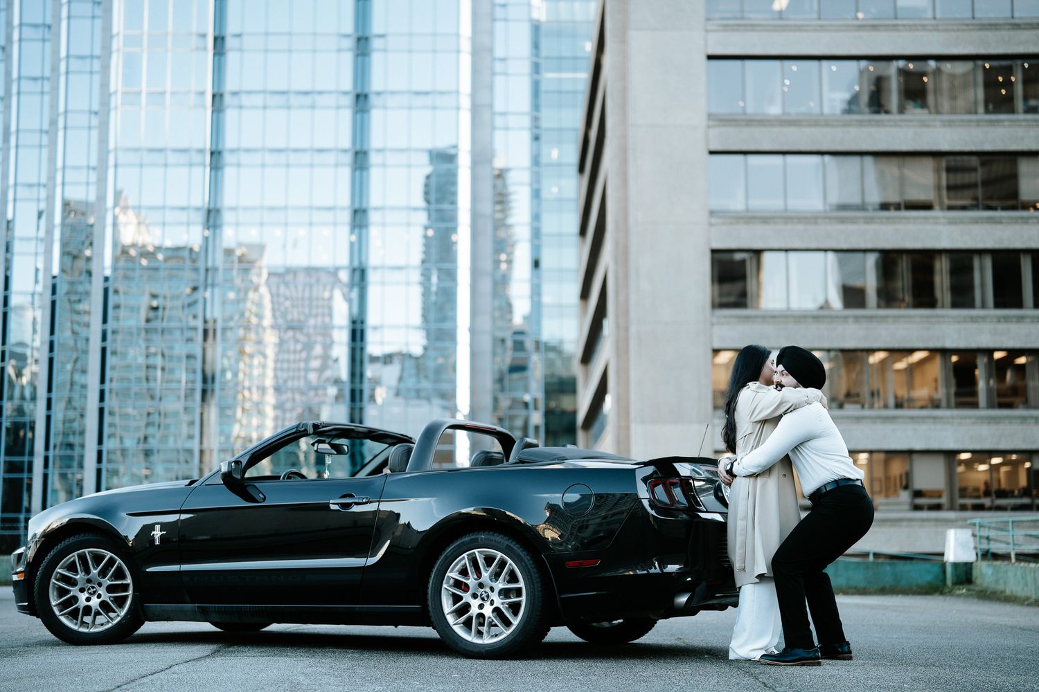 A series of black BMW Z8 sports cars parked in a row outside a modern glass building.