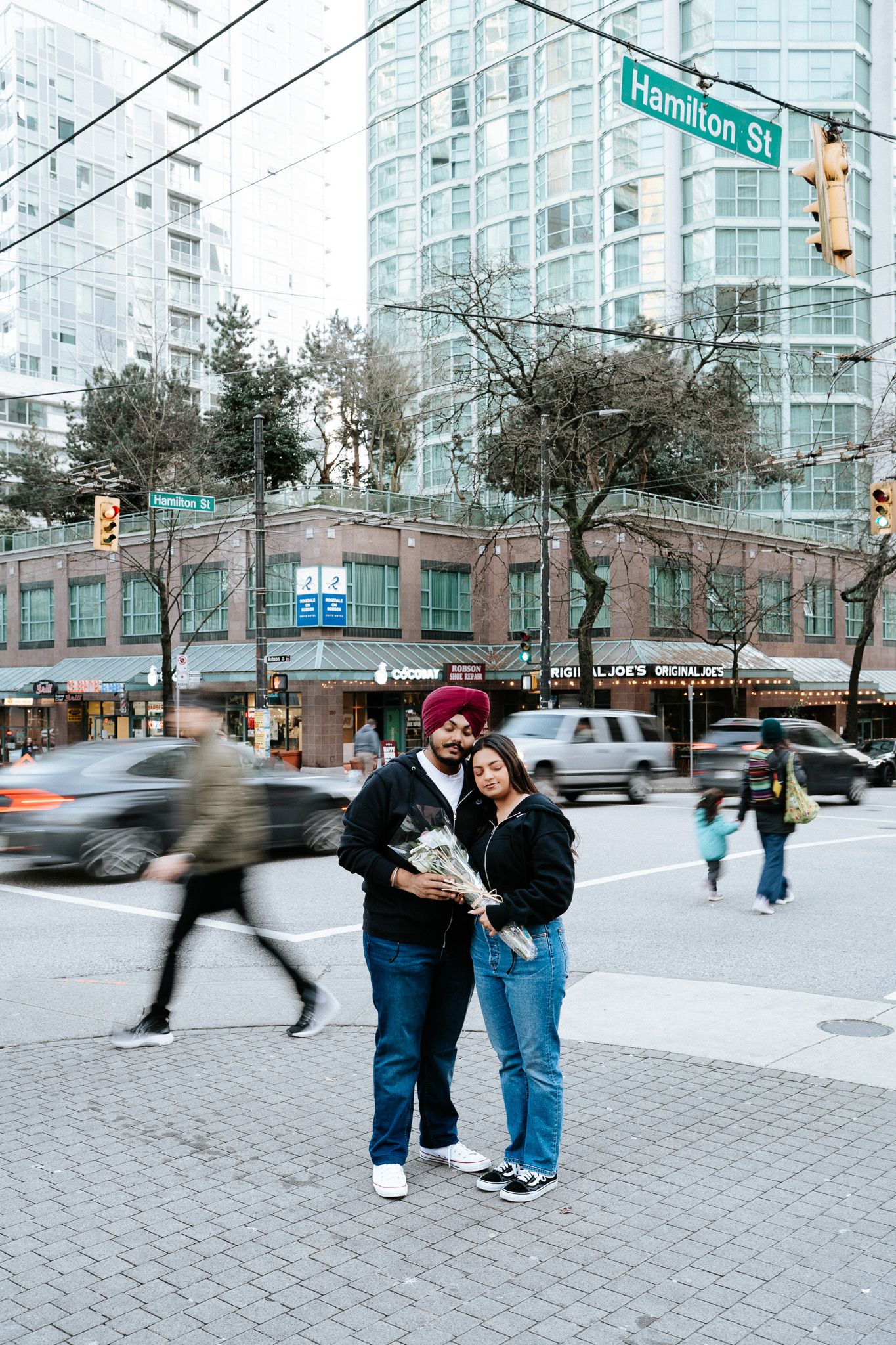 A sequence of motion blur photos showing people walking at an urban street corner with glass buildings in background.