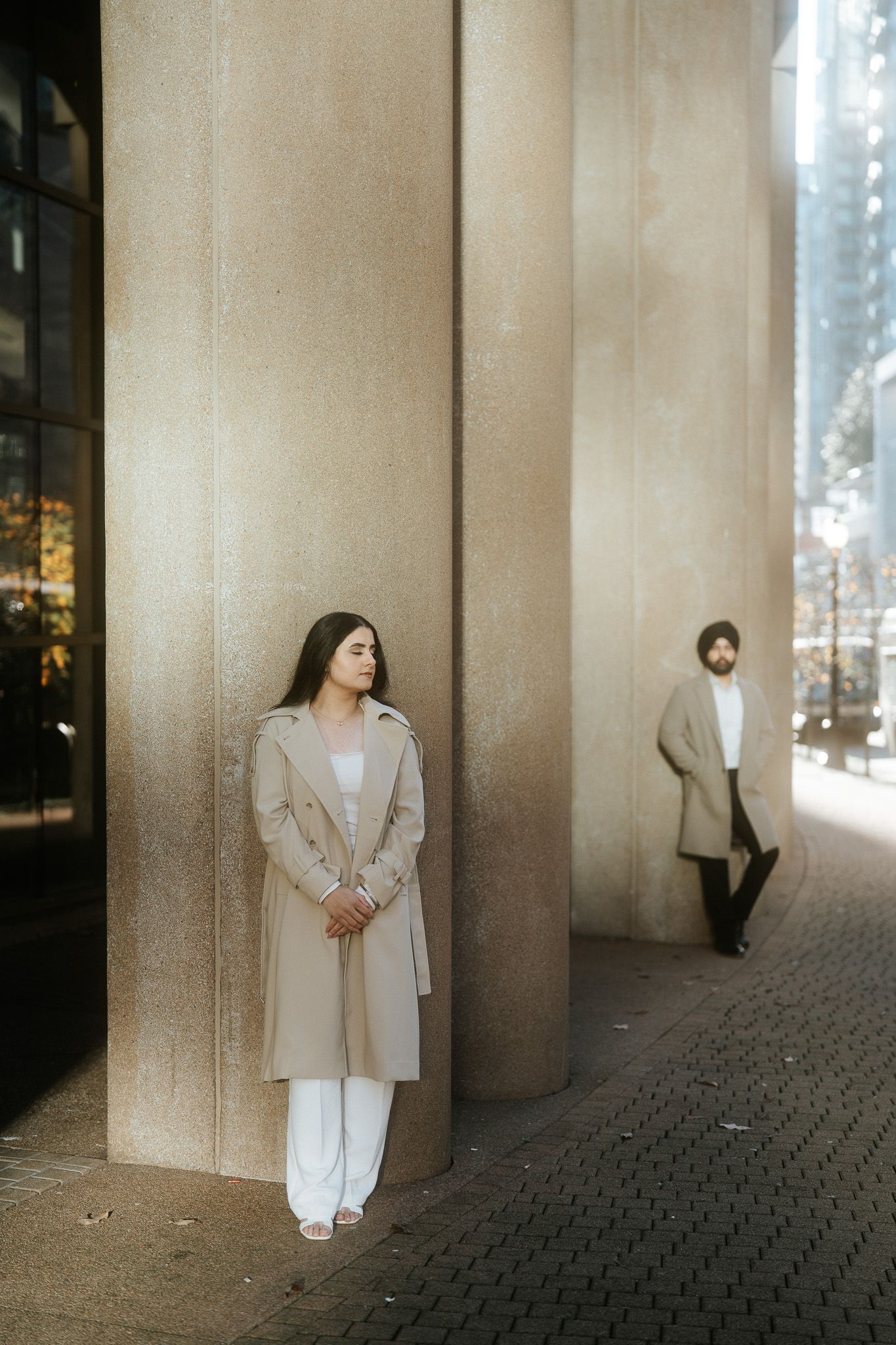 A series of minimalist fashion portraits showing figures in white and beige clothing against concrete walls and stone floors.