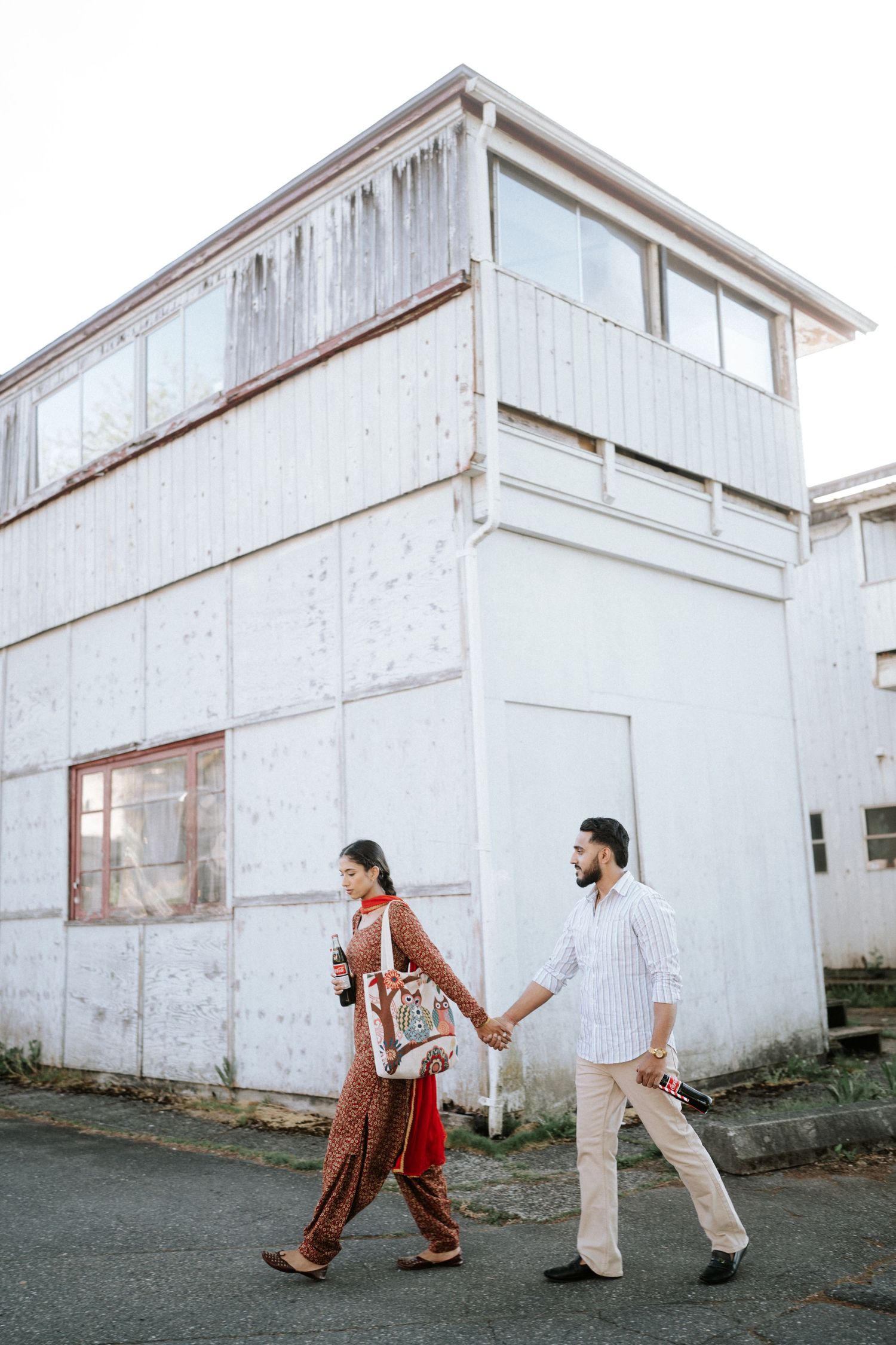 A creative dance sequence showing movement and interaction between two people against a white industrial building exterior.