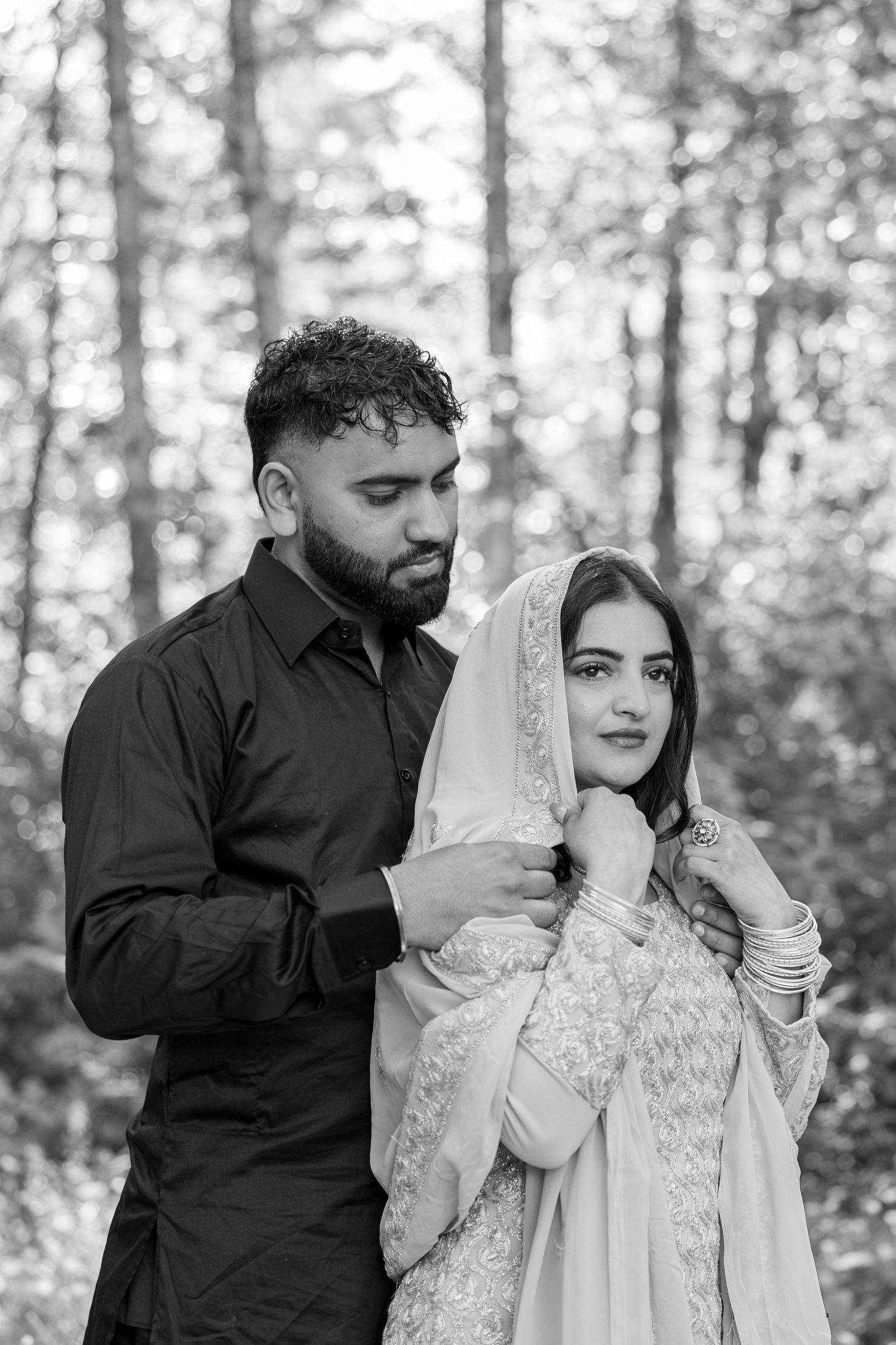 Black and white romantic portraits captured in a serene forest setting.