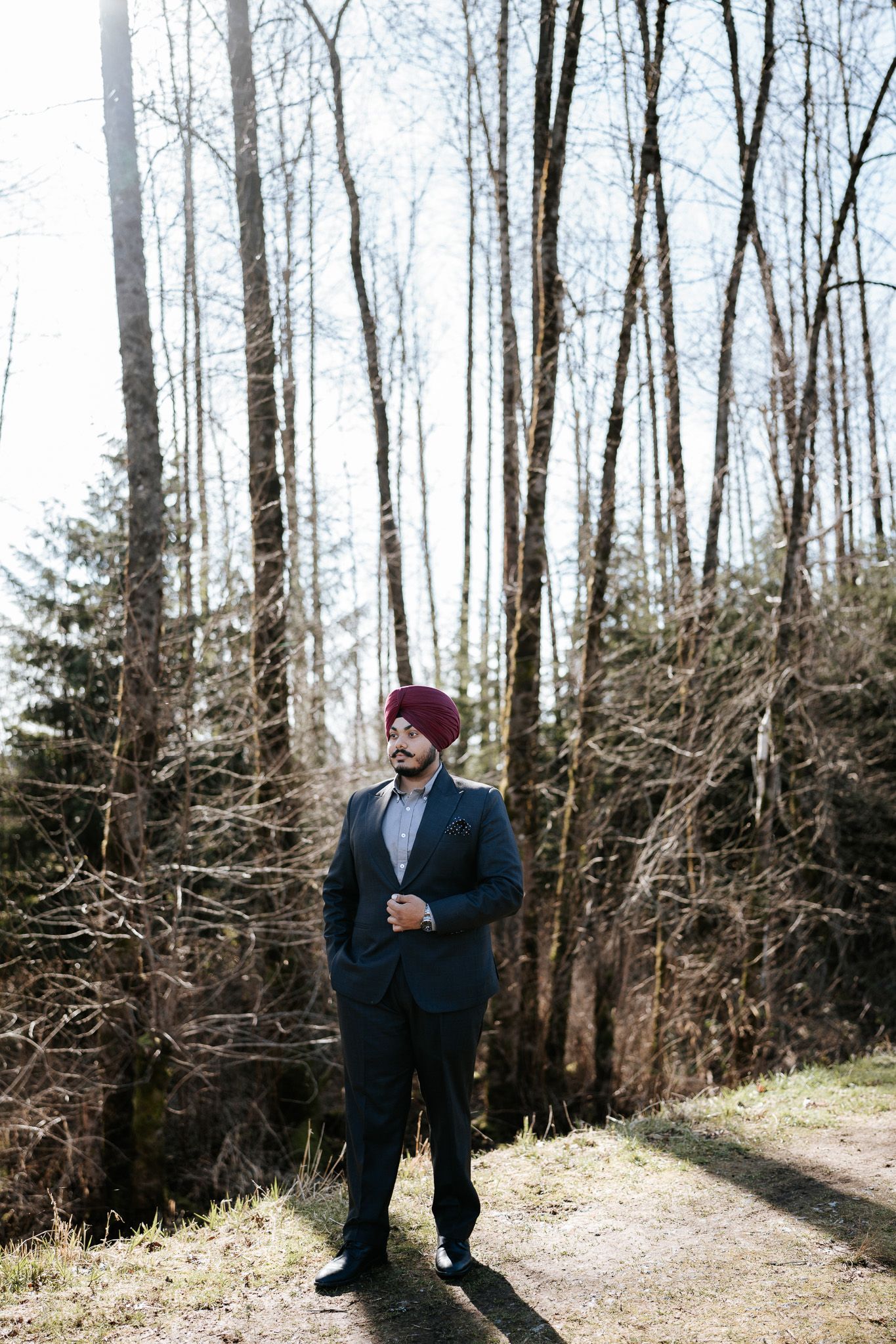 A scenic winter forest path with bare trees and evergreens creates a natural outdoor setting.