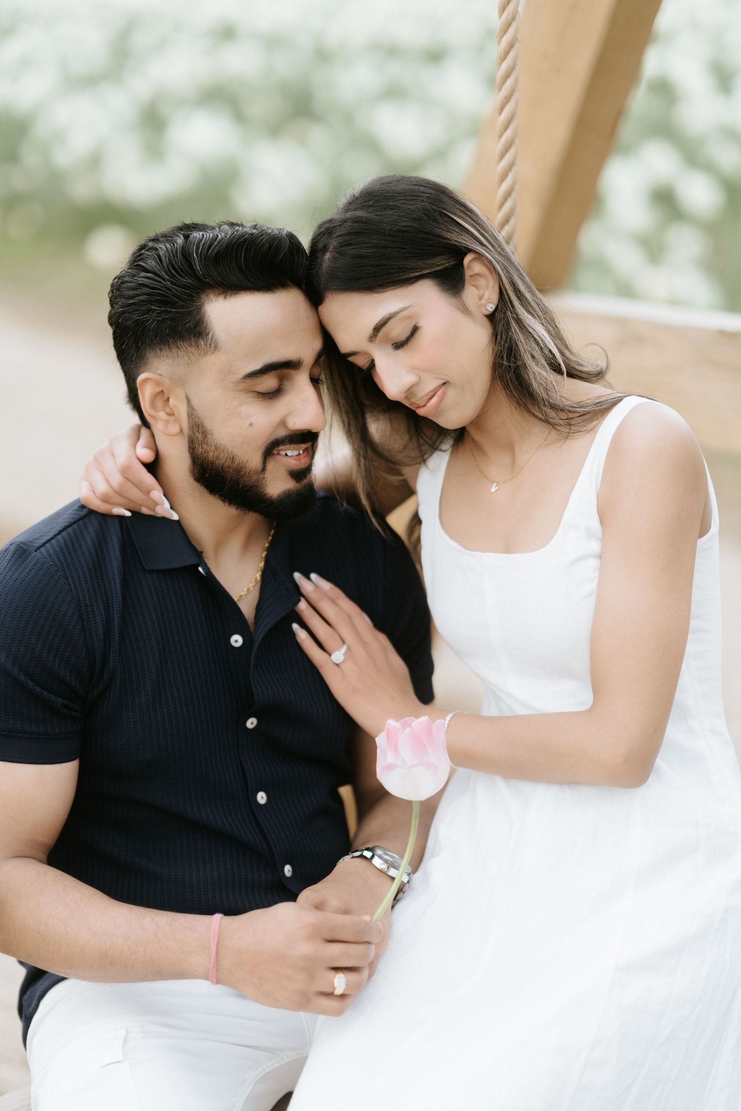 A romantic couple in black and white attire share intimate moments in a series of tender engagement photos.