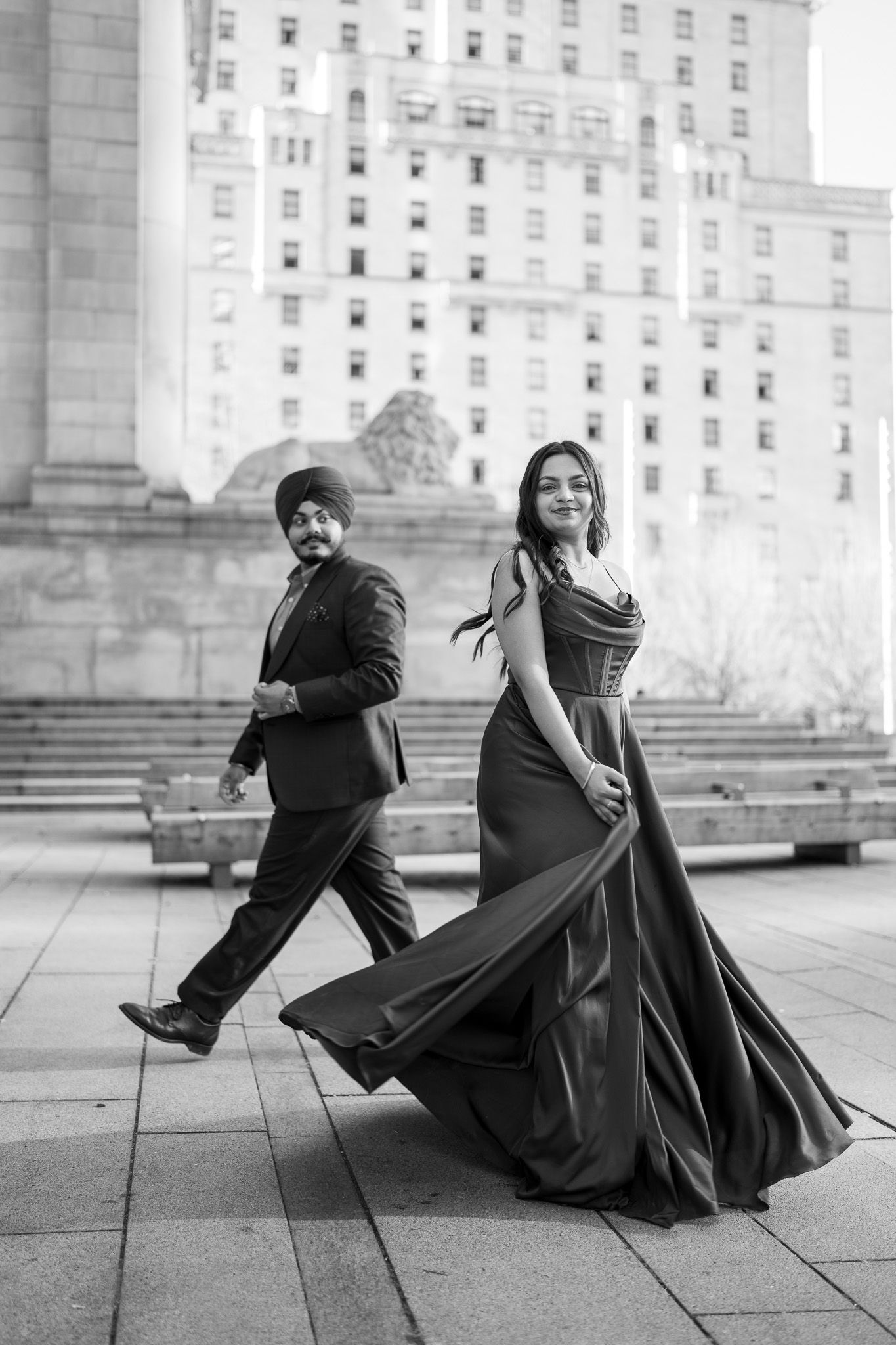 Black and white photos capturing playful dance movements in front of a grand building.