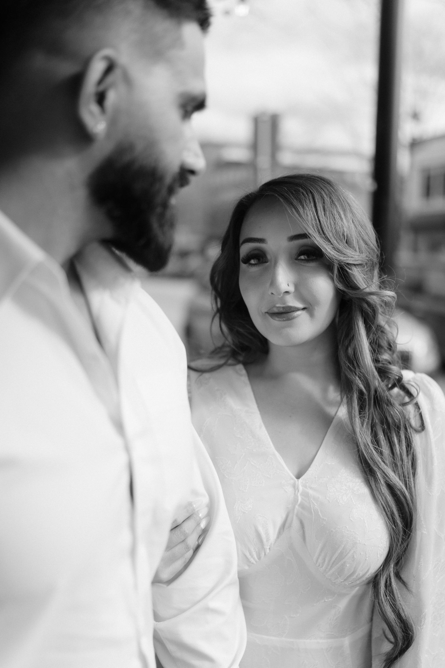 A black and white intimate portrait of a couple gazing at each other.