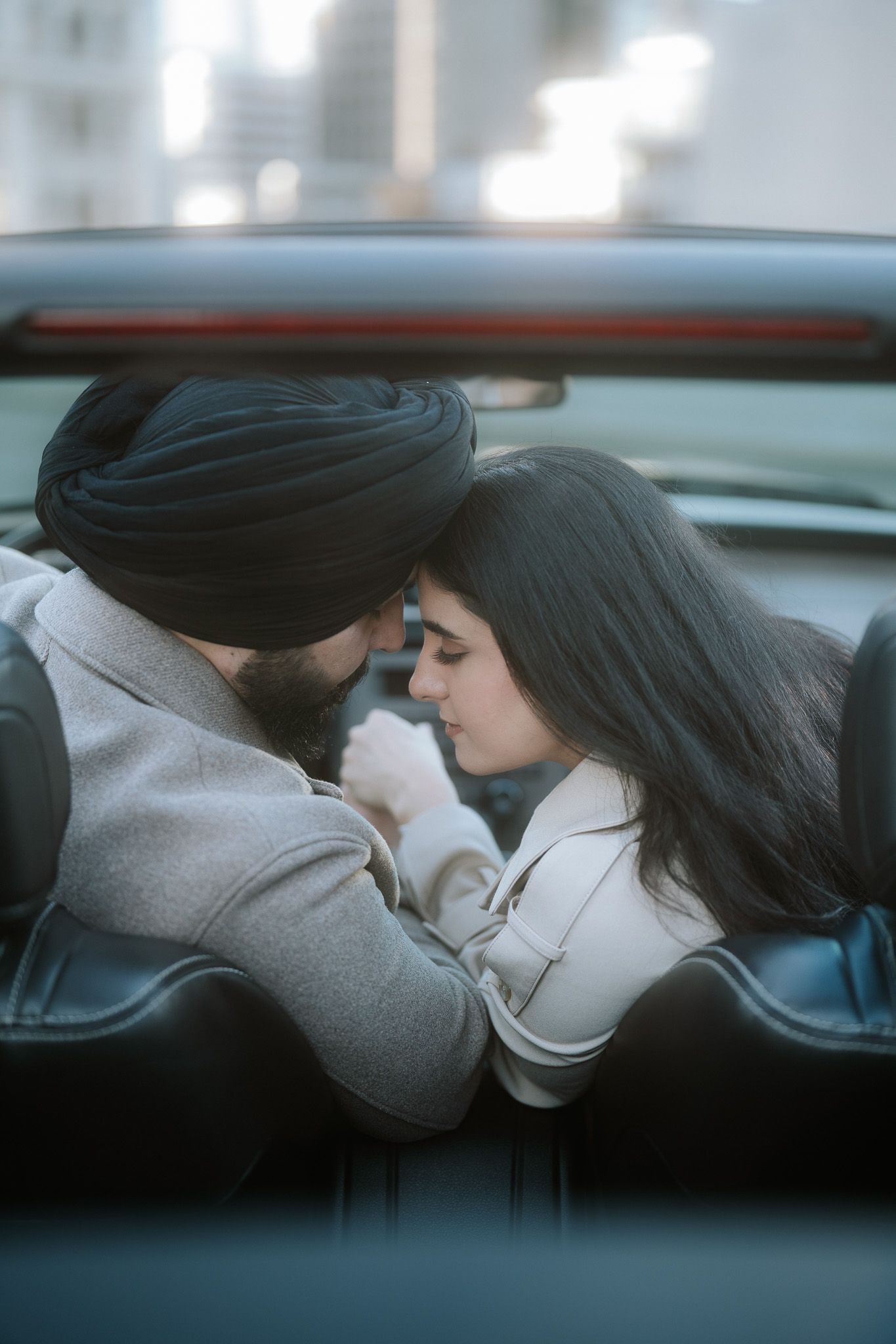 A couple shares an intimate moment in the backseat of a car in a series of moody, blue-tinted photographs.