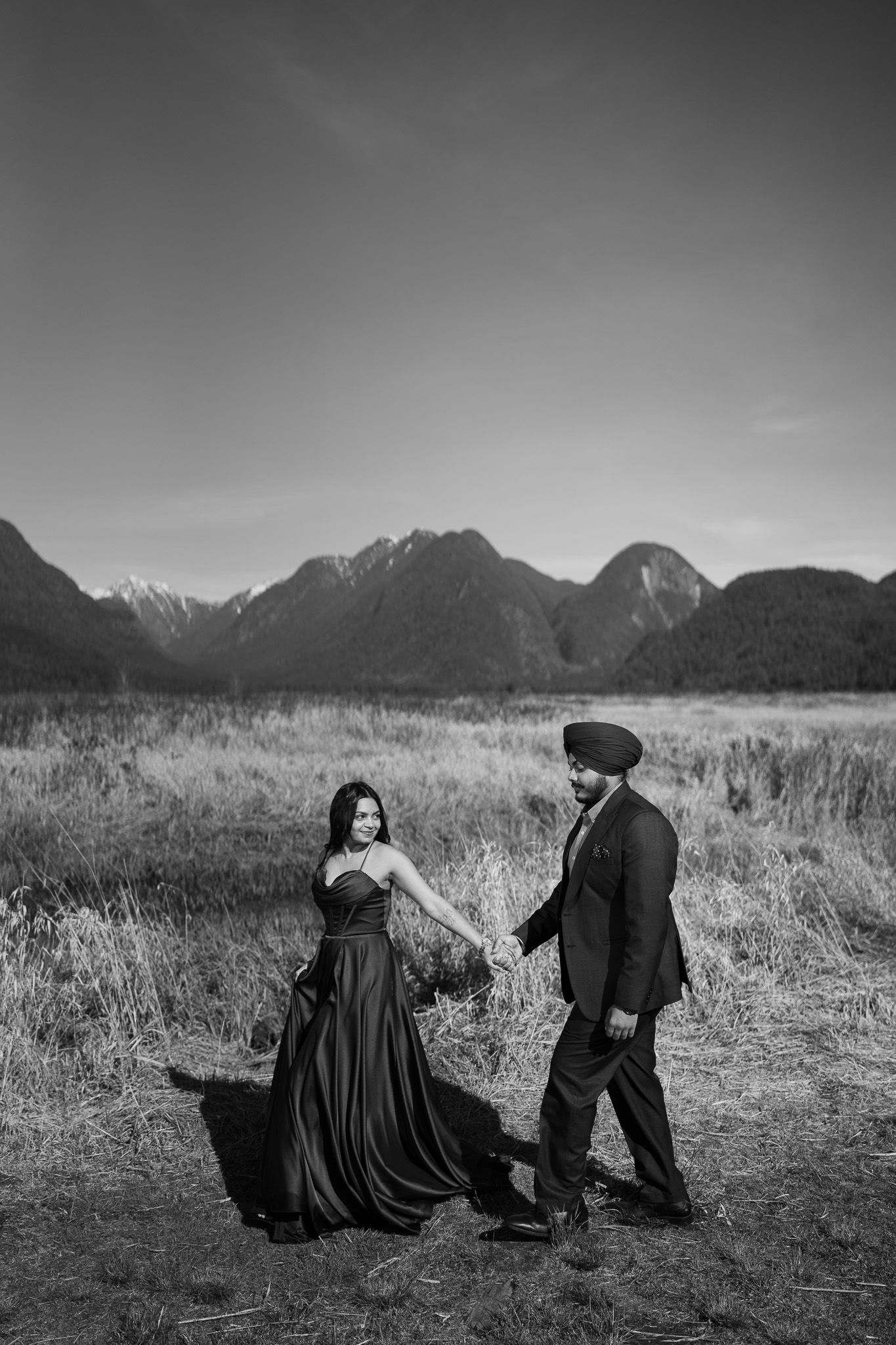A dramatic black and white photo sequence showing a couple in a field with mountains in the background.