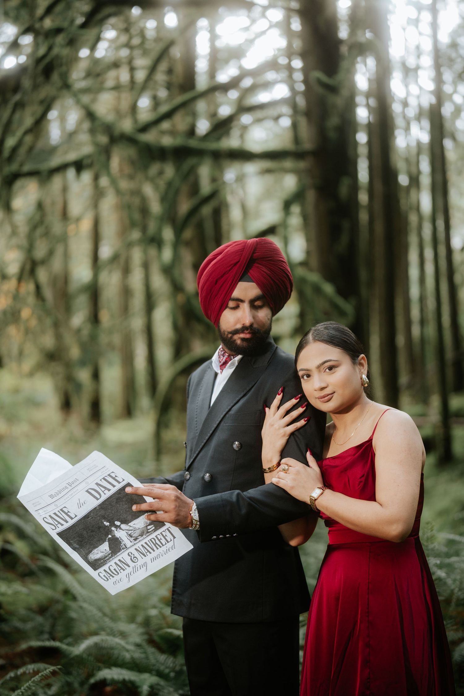 Elegant couple poses with newspapers in a misty Pacific Northwest forest setting.