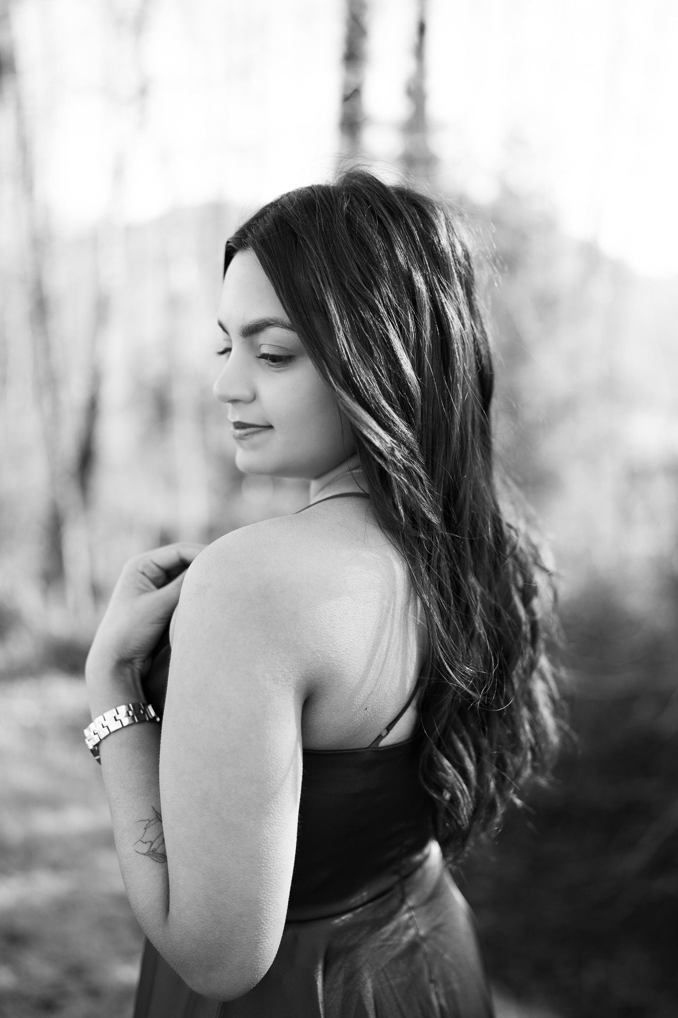 Black and white artistic portrait series showing dramatic side profile poses against blurred natural background.