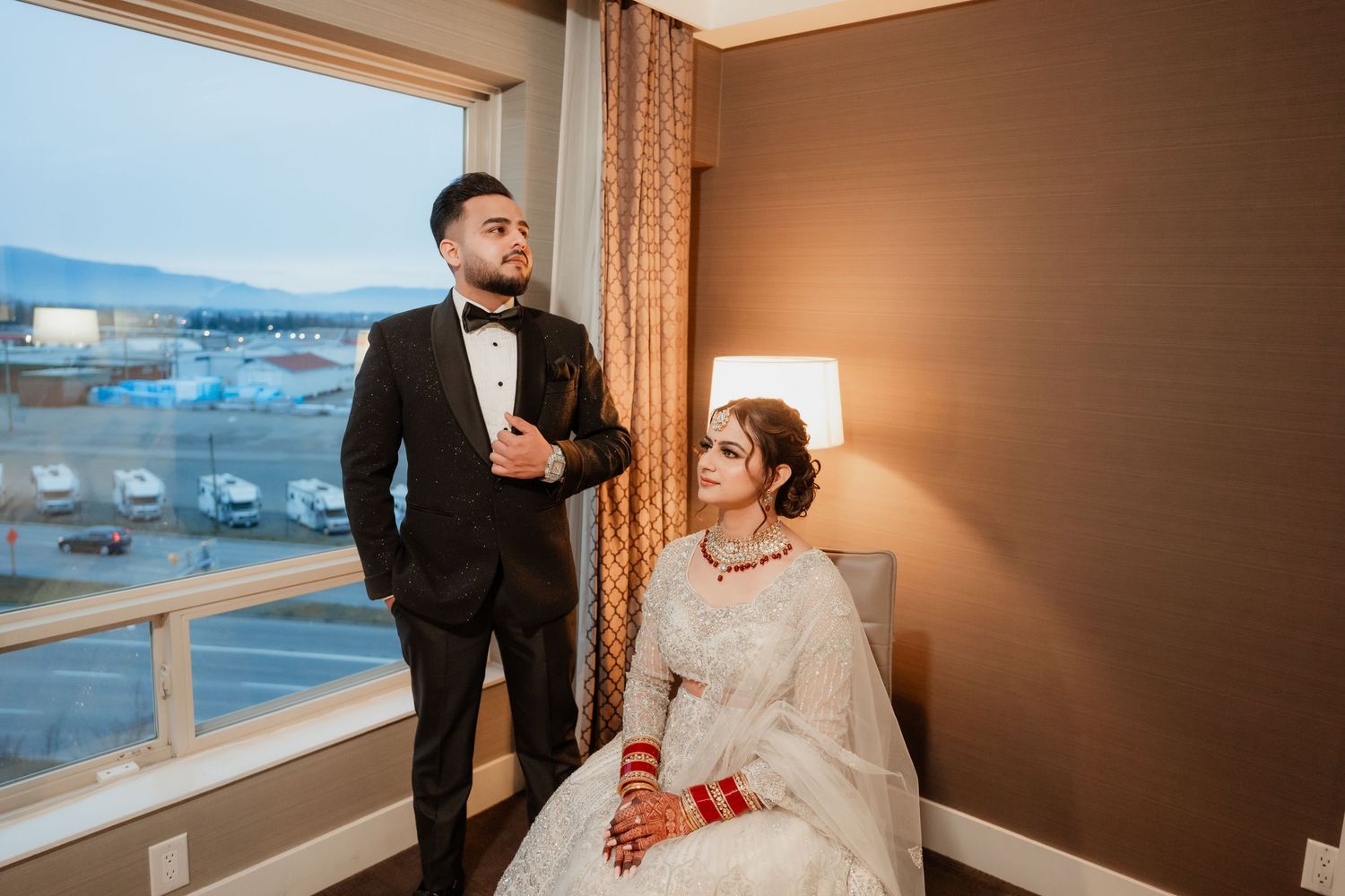 A couple shares a romantic moment in a hotel room with a window view.