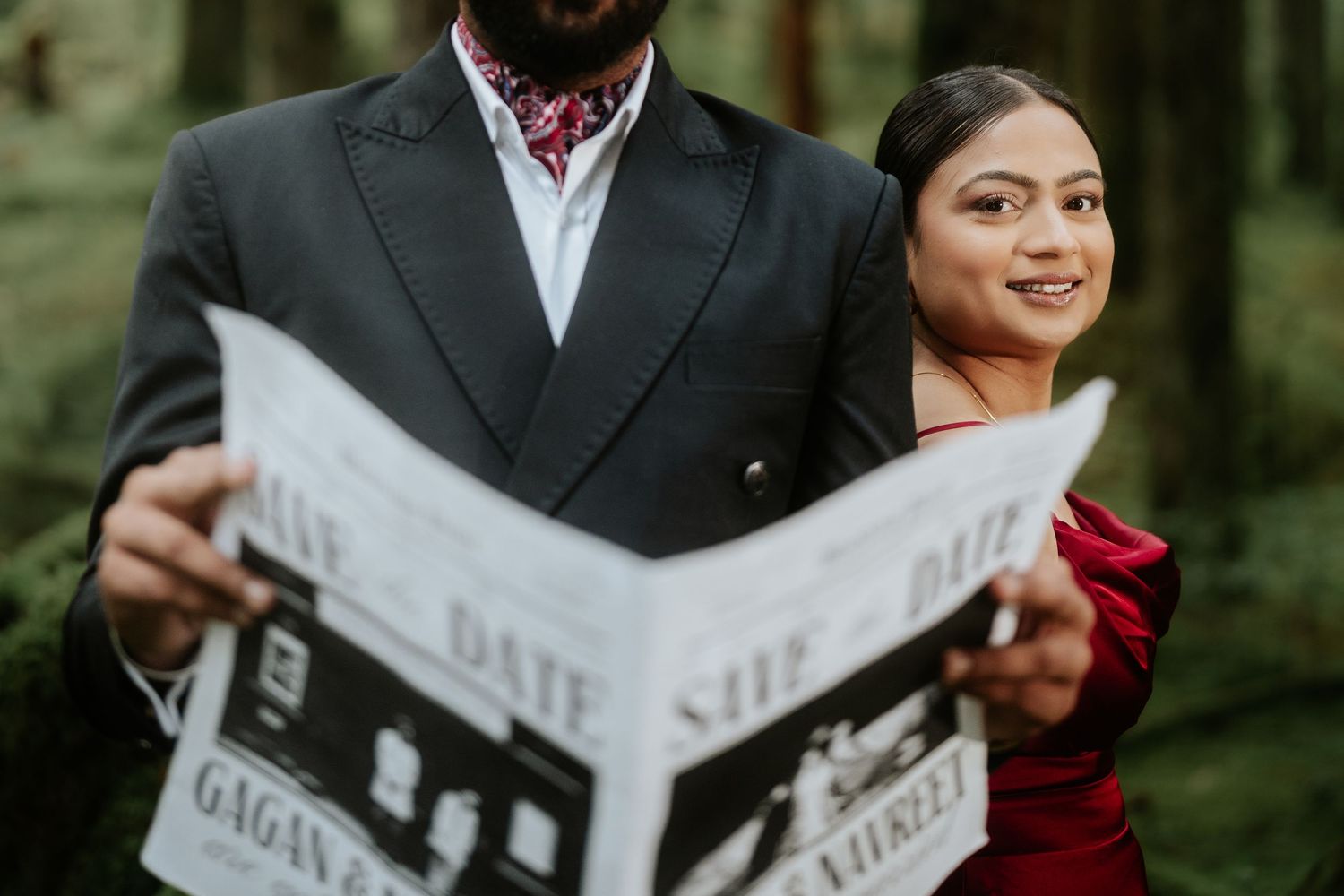 Close-up shot of couple reading newspapers during forest engagement photoshoot.