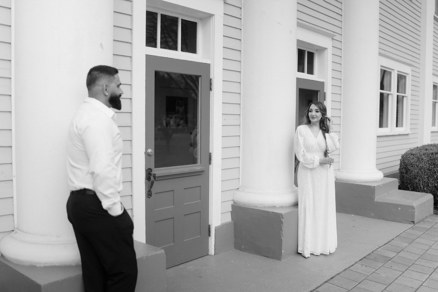 Classic architectural detail of white columns and doorways along a building facade.