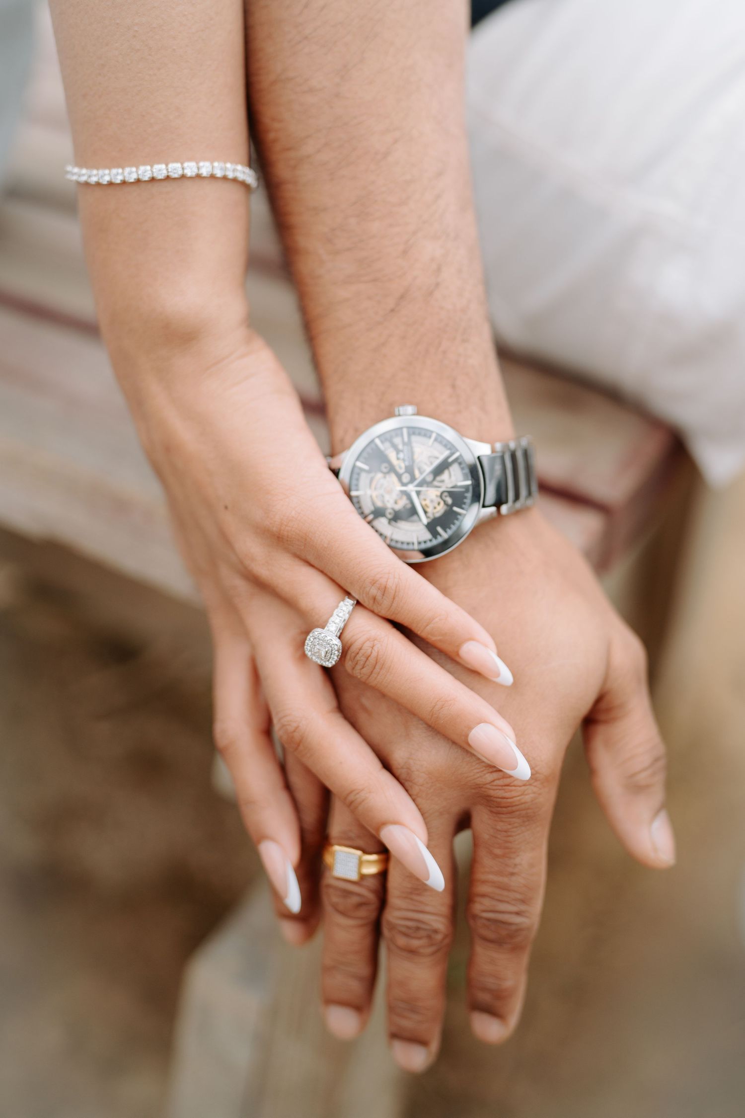 Close-up shots of hands wearing various diamond rings and wedding bands with manicured nails on display.