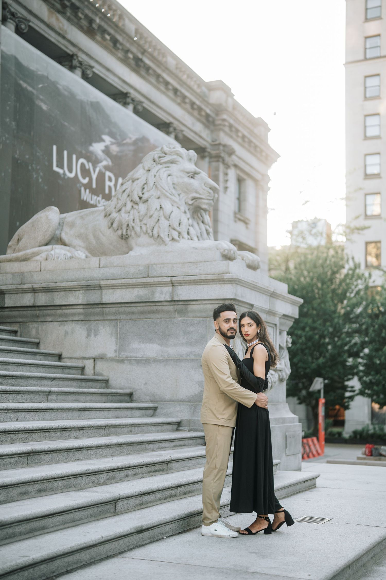 A couple poses together on grand stone steps of a historic building during a romantic photoshoot.