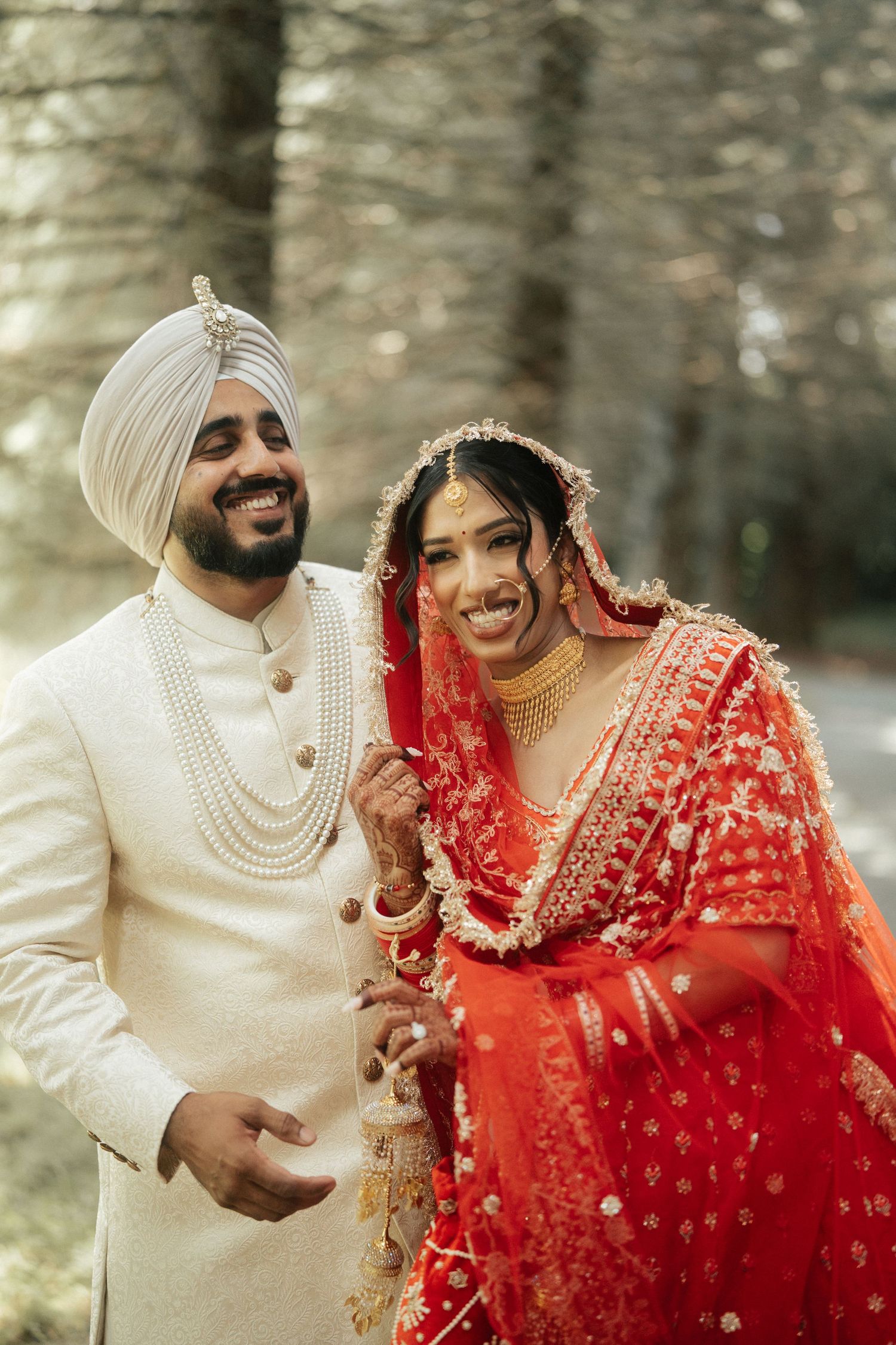 Joyful wedding couple sharing intimate moments in traditional Sikh and Indian wedding attire.