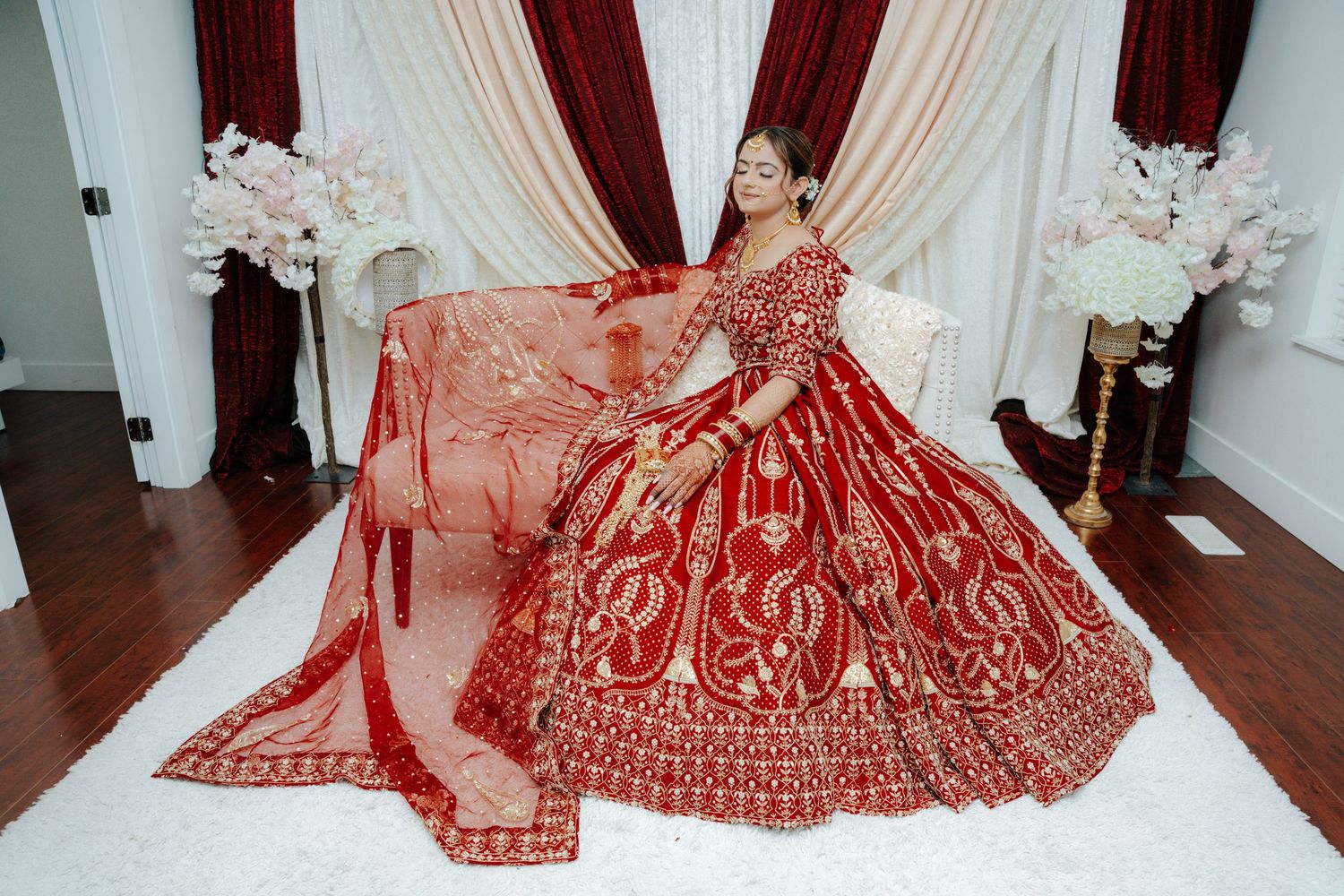 Wedding ceremony setting with elegant white and red decor in a traditional venue.