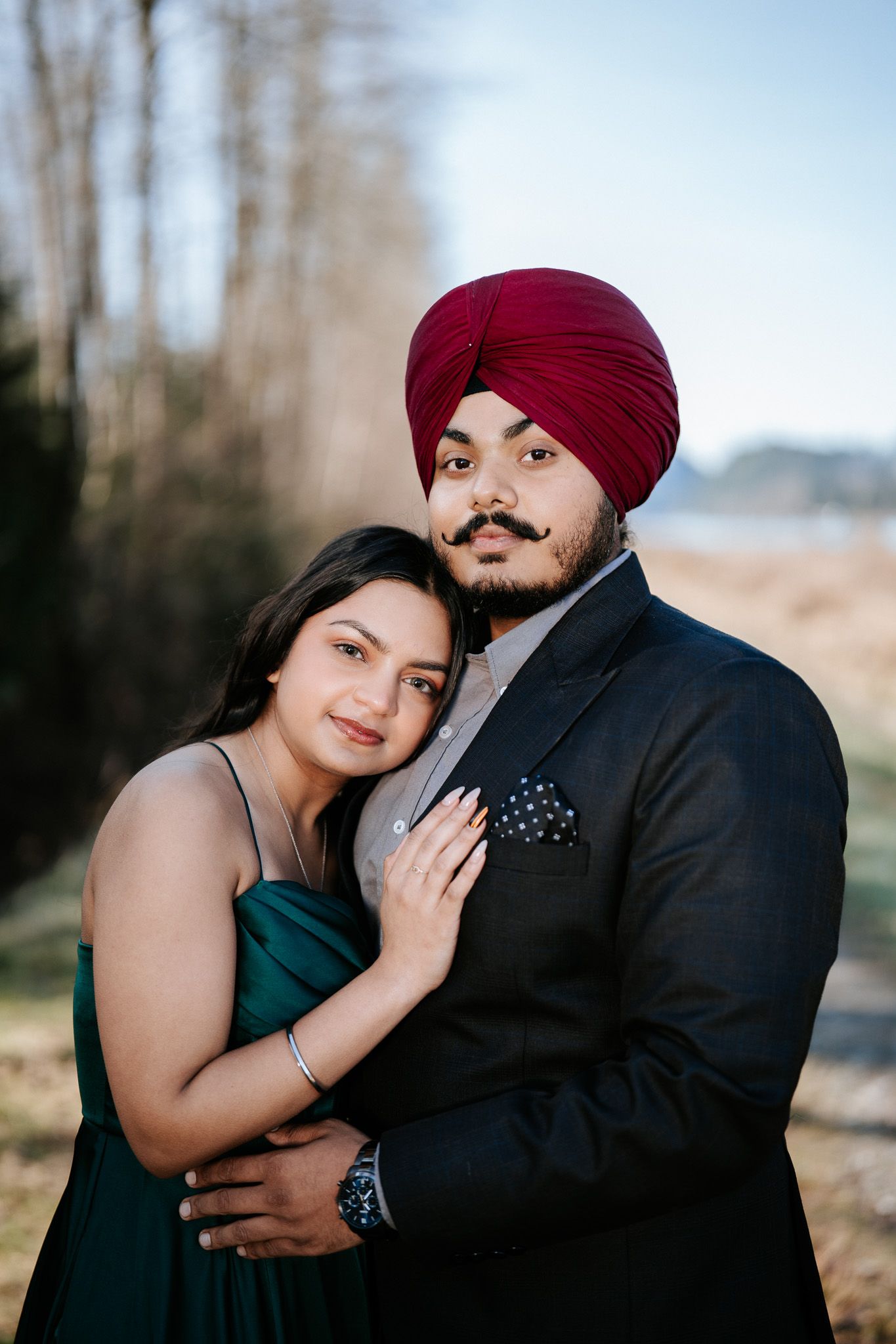 A romantic couple in formal attire embraces outdoors during a photo session with multiple intimate poses.