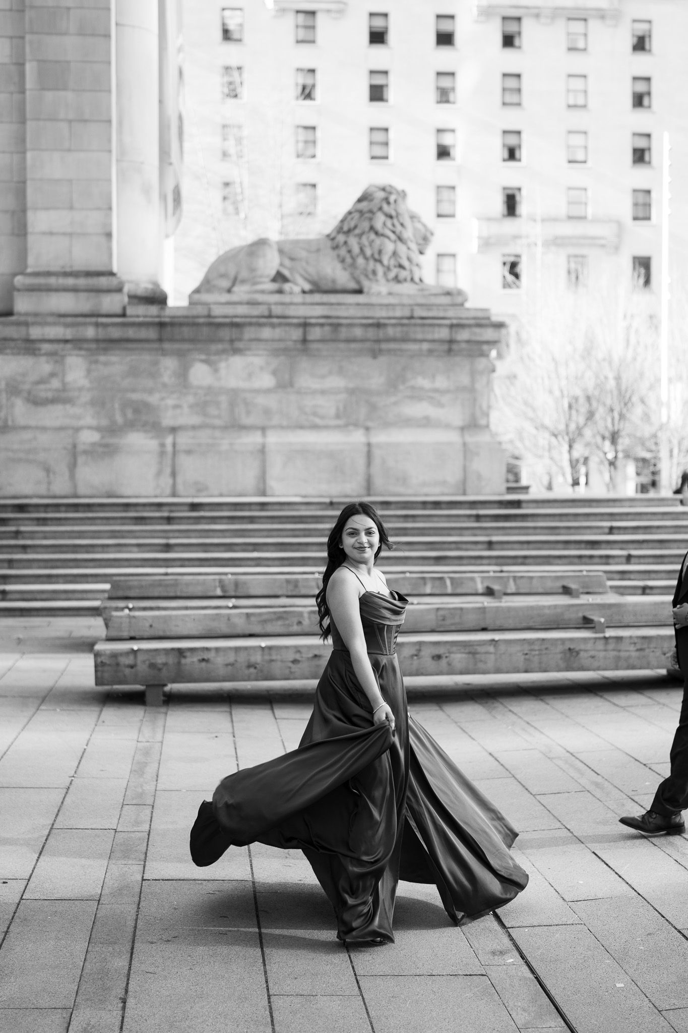 A black and white photo sequence shows a flowing dress in motion across stone steps of a classical building.