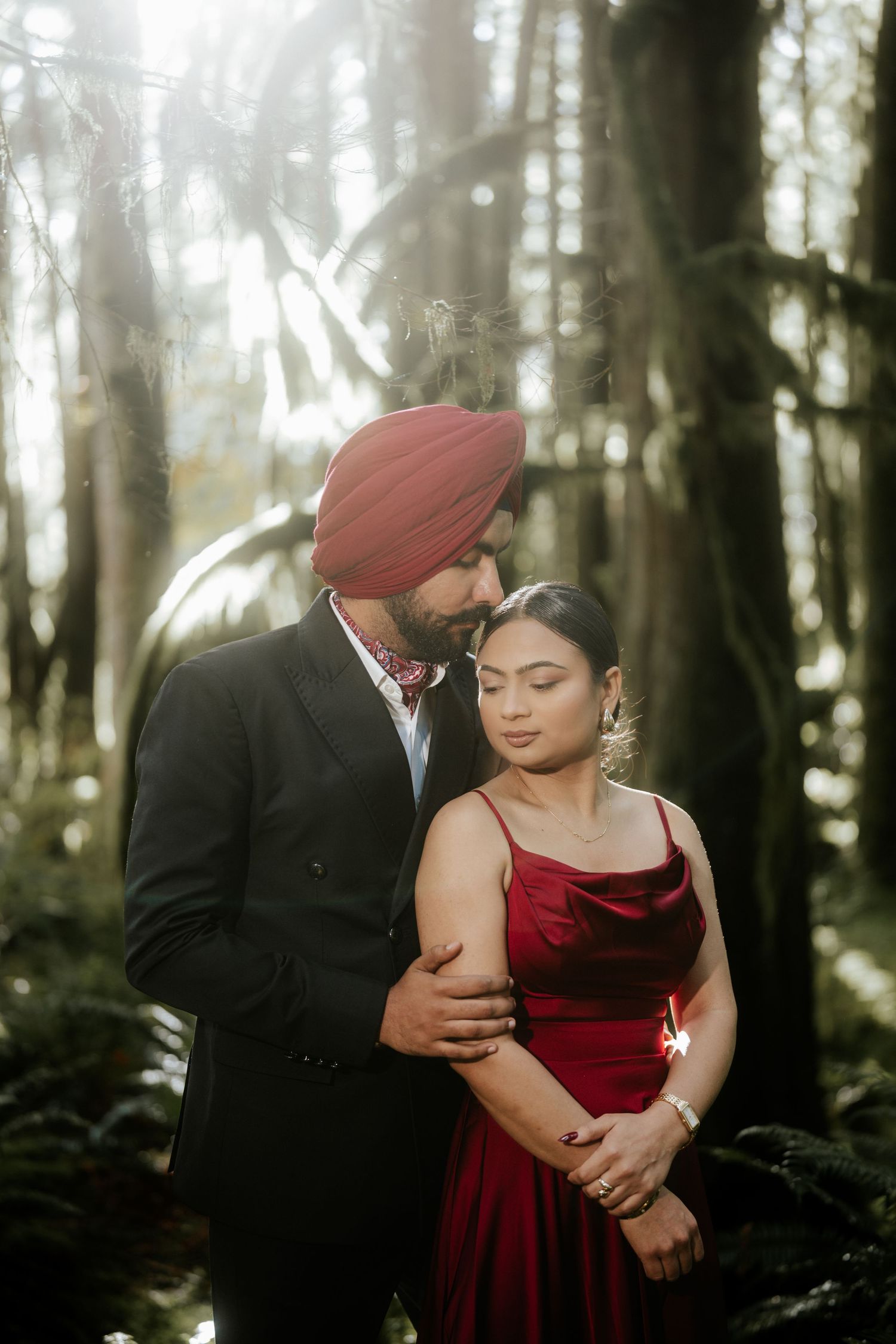 Intimate forest photoshoot featuring velvet red dress and dramatic lighting.
