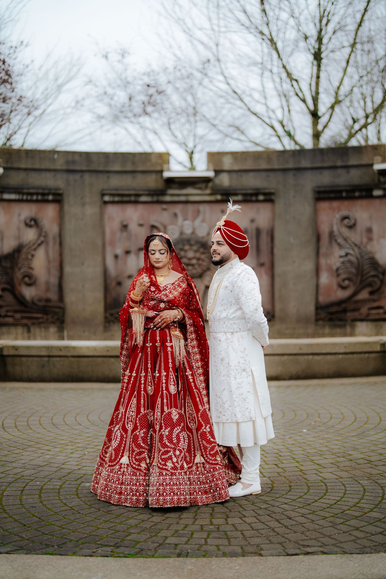 Outdoor wedding photoshoot on circular stone pavement with traditional attire.