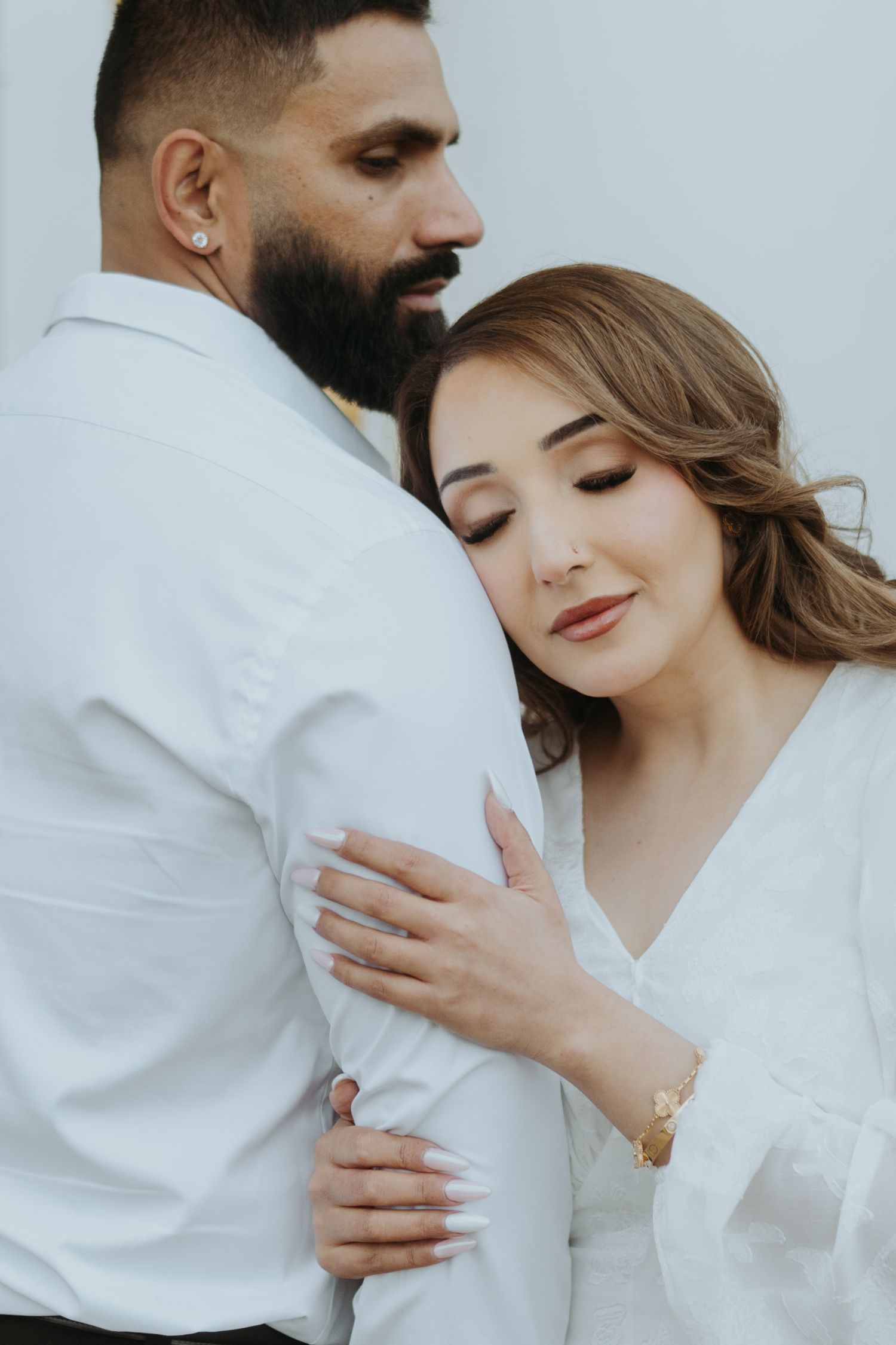 Close-up portraits of a couple in white sharing intimate moments together.
