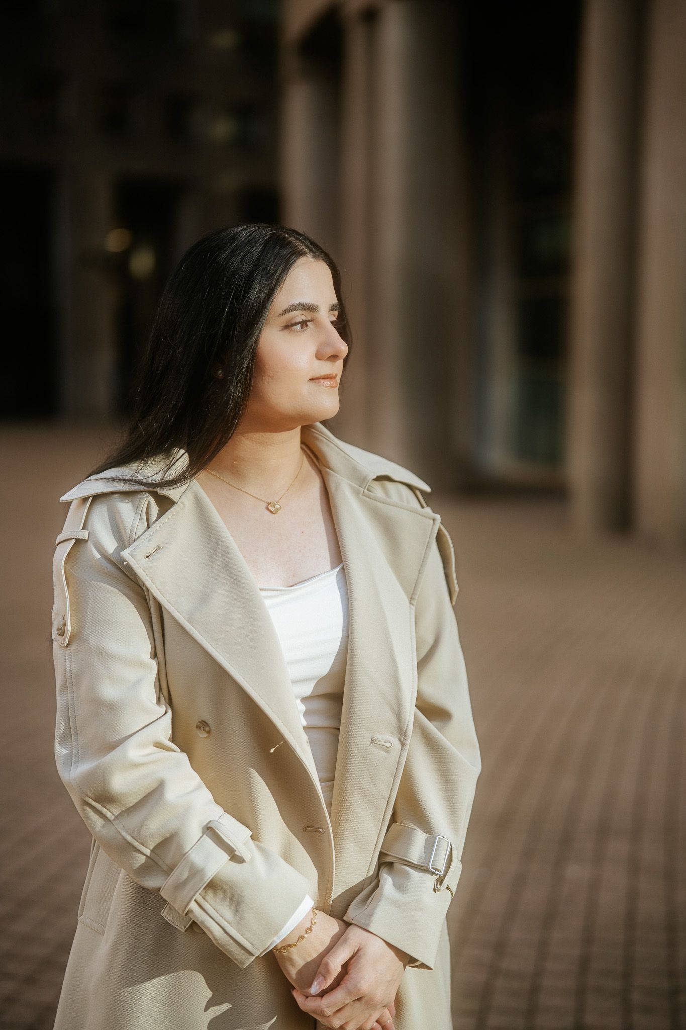 A fashion portrait series showing someone wearing a cream-colored blazer against a blurred architectural background.