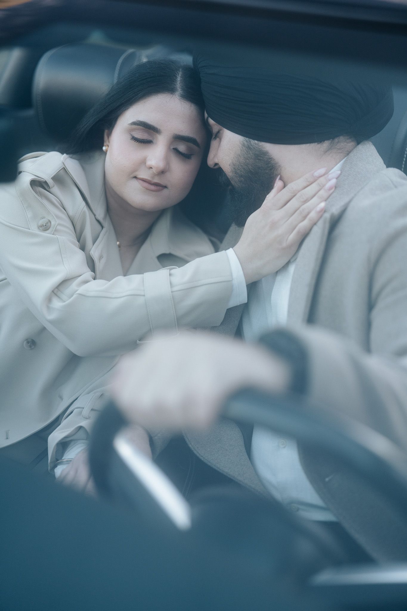 A couple shares an intimate moment while resting together in the backseat of a car.