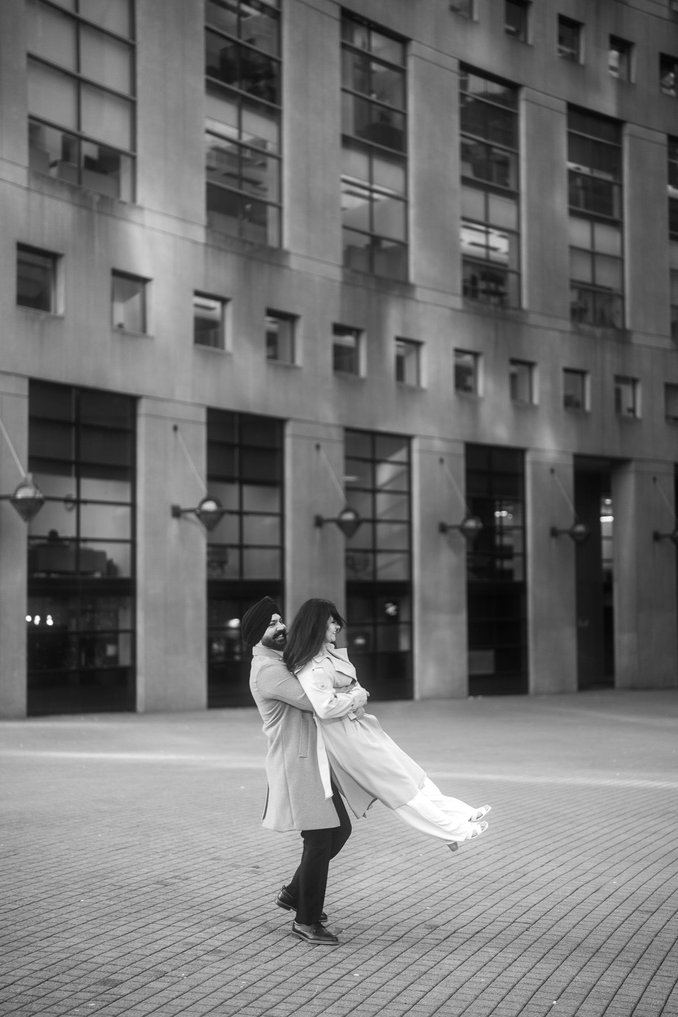 A black and white sequence of a couple dancing in an urban plaza with dramatic spinning movements.