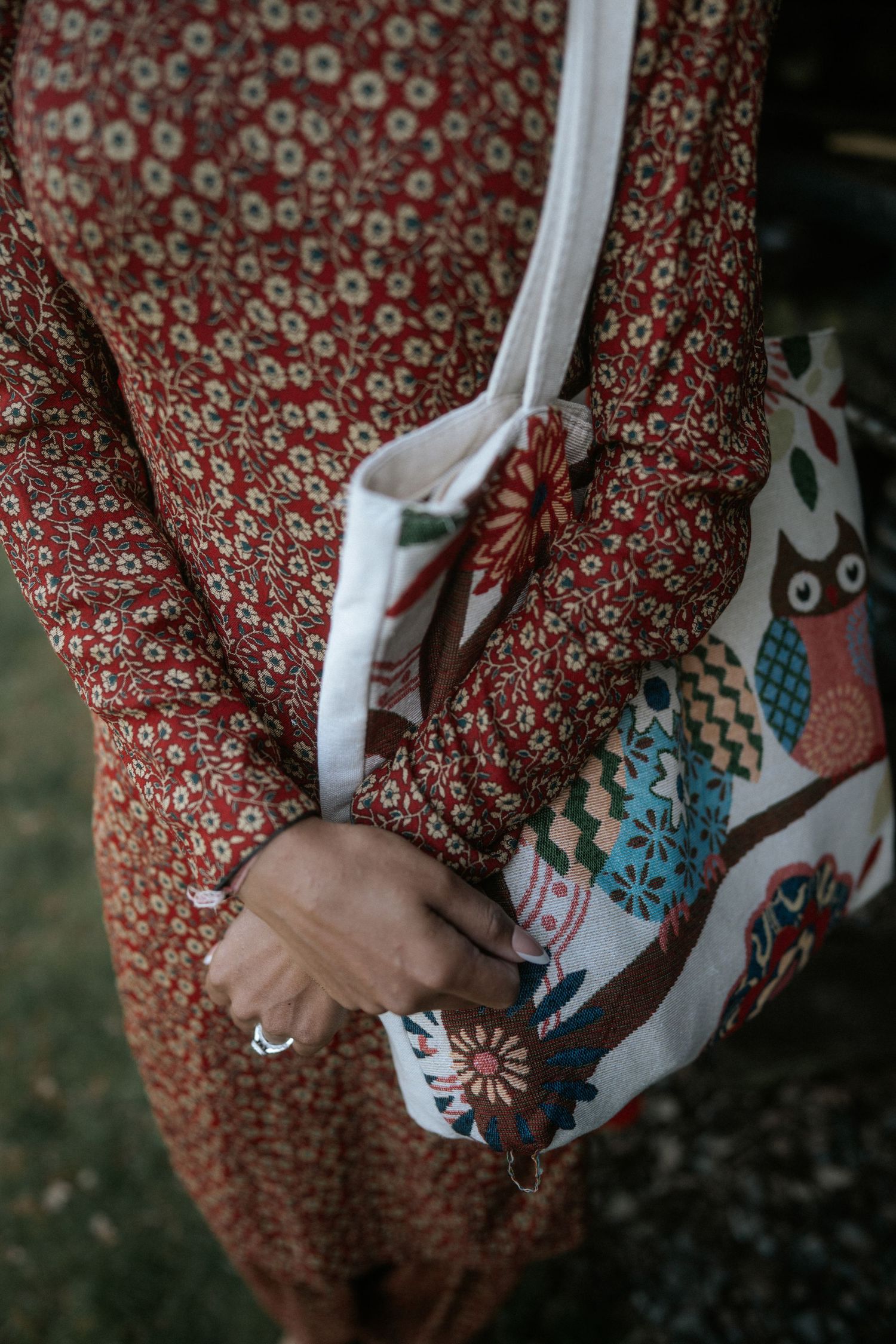 Close-up sequence of hands holding a red and white floral patterned dress against a dark background.
