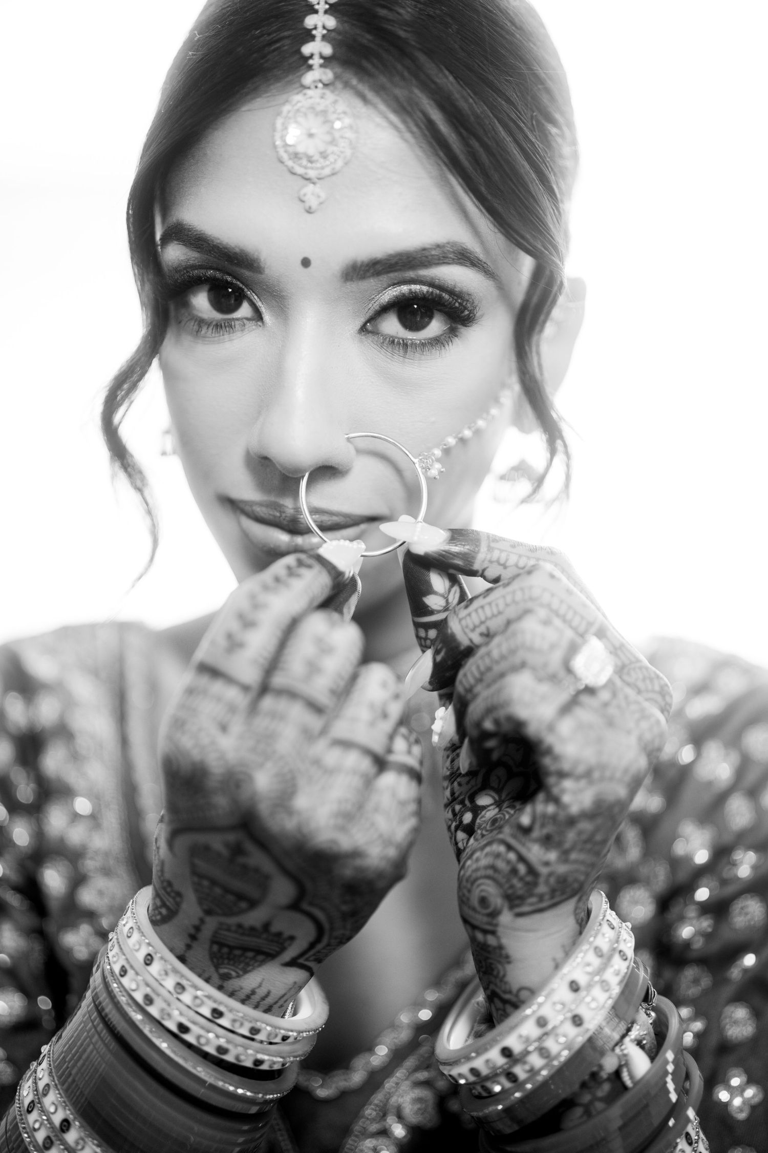 Black and white close-up portraits showing intricate bridal mehndi and jewelry details.