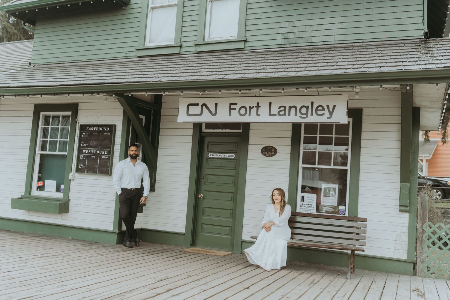 Historic green wooden building with CN Fort Langley signage and wooden deck walkway.