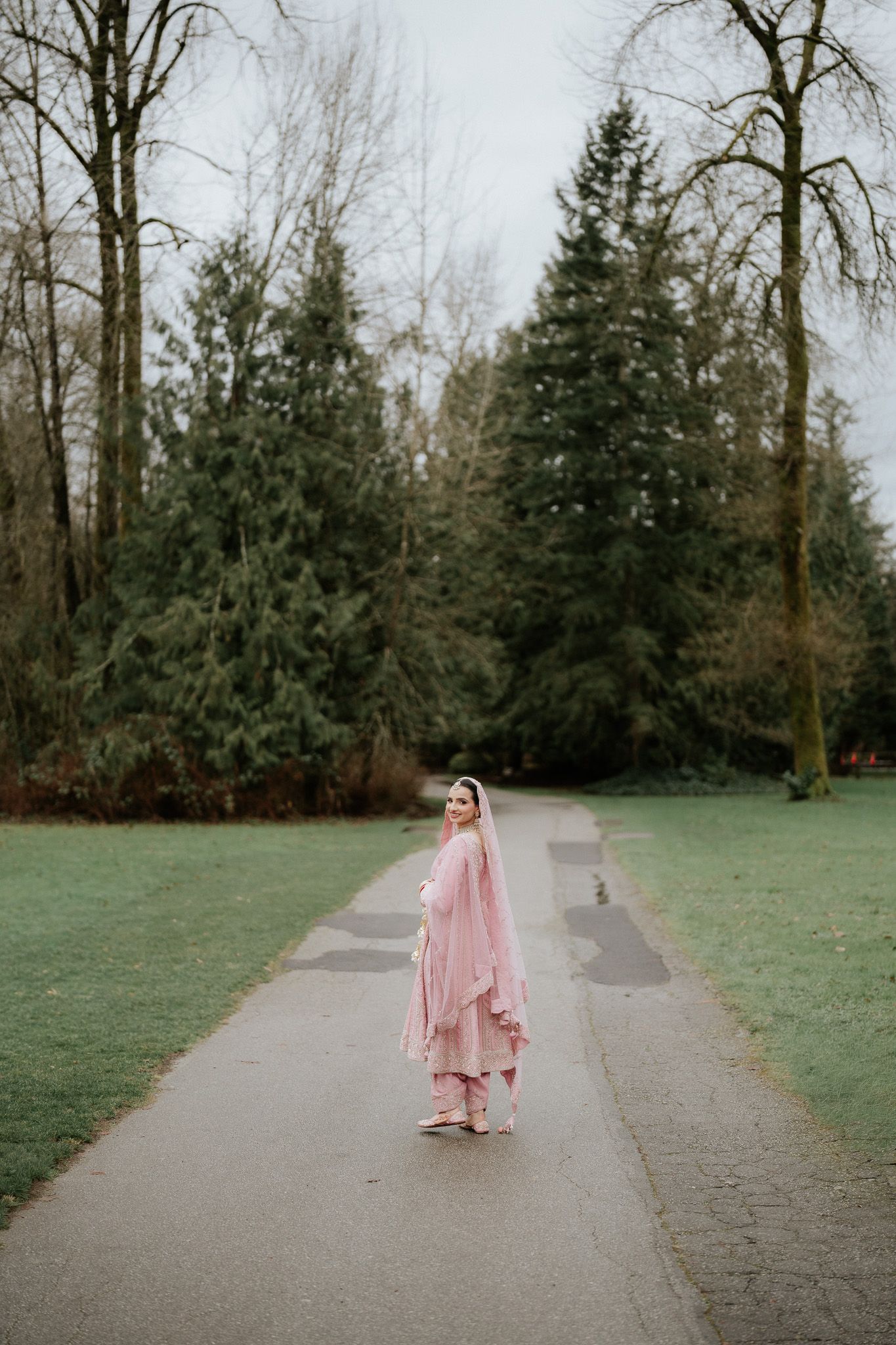 A sequence of photos showing a person in a pink dress walking along a tree-lined path in a park setting.