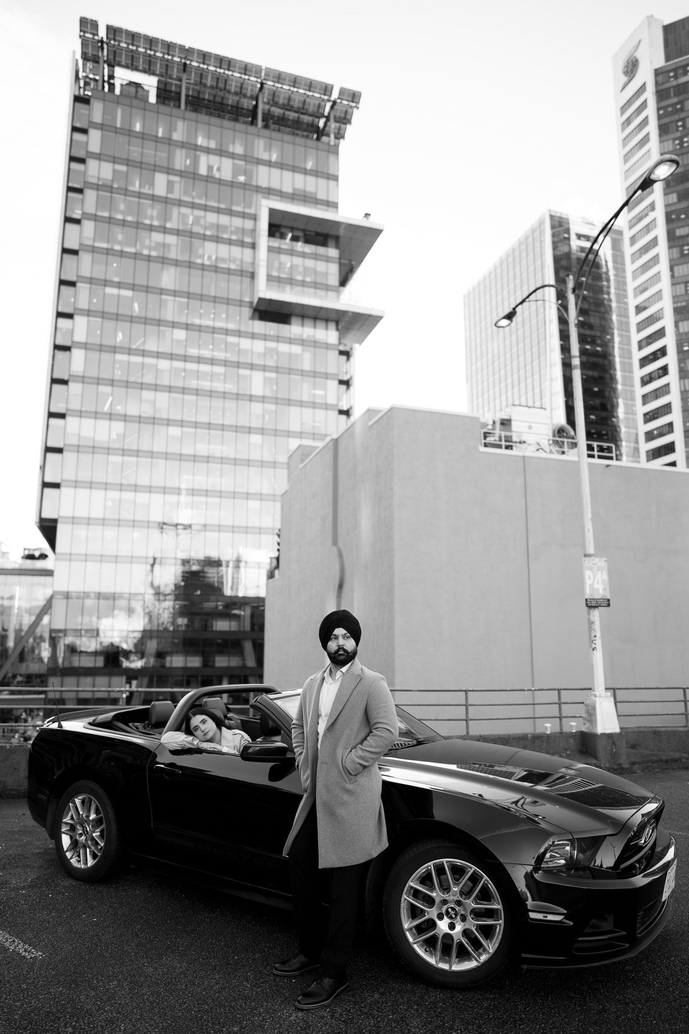 Black and white photo series showing a luxury sports car and person in formal attire against modern glass buildings.