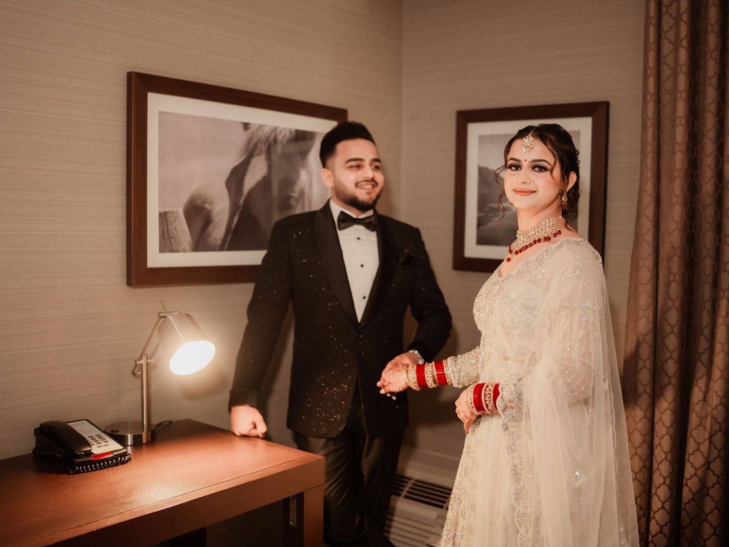 A couple shares intimate moments in a hotel room with warm lighting.