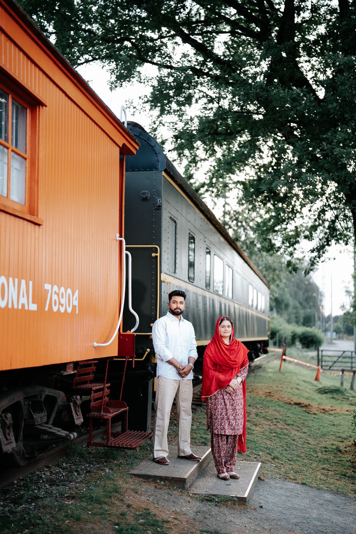 Couple standing together at entrance of vintage Canadian National railway car 76904 at Fort Langley.