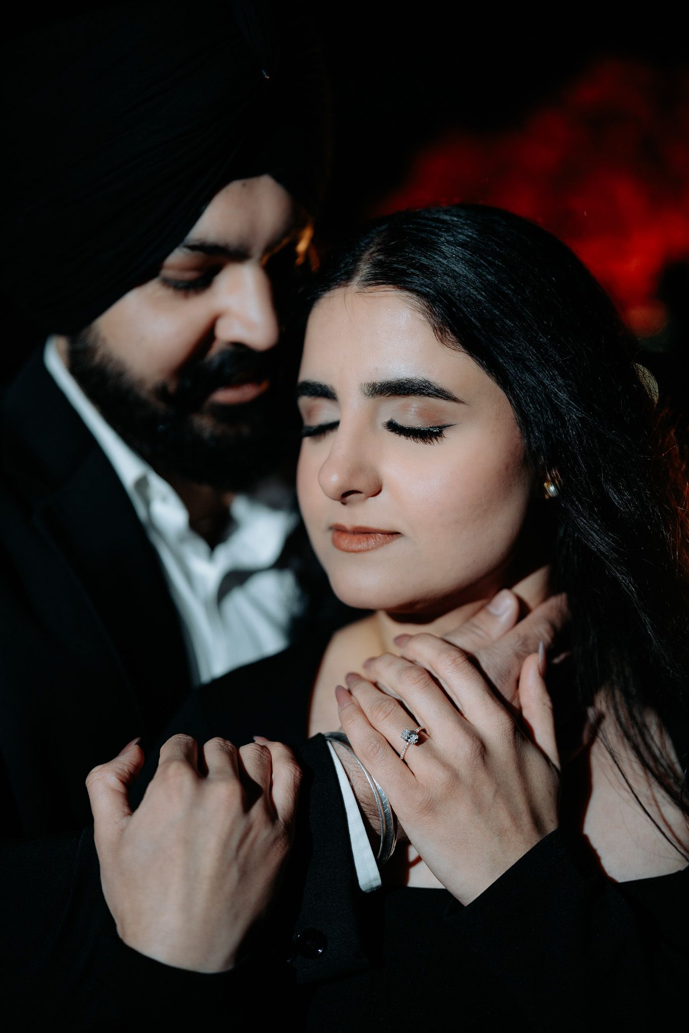 Intimate dark and moody engagement photos showing tender moments between a couple in dramatic lighting.