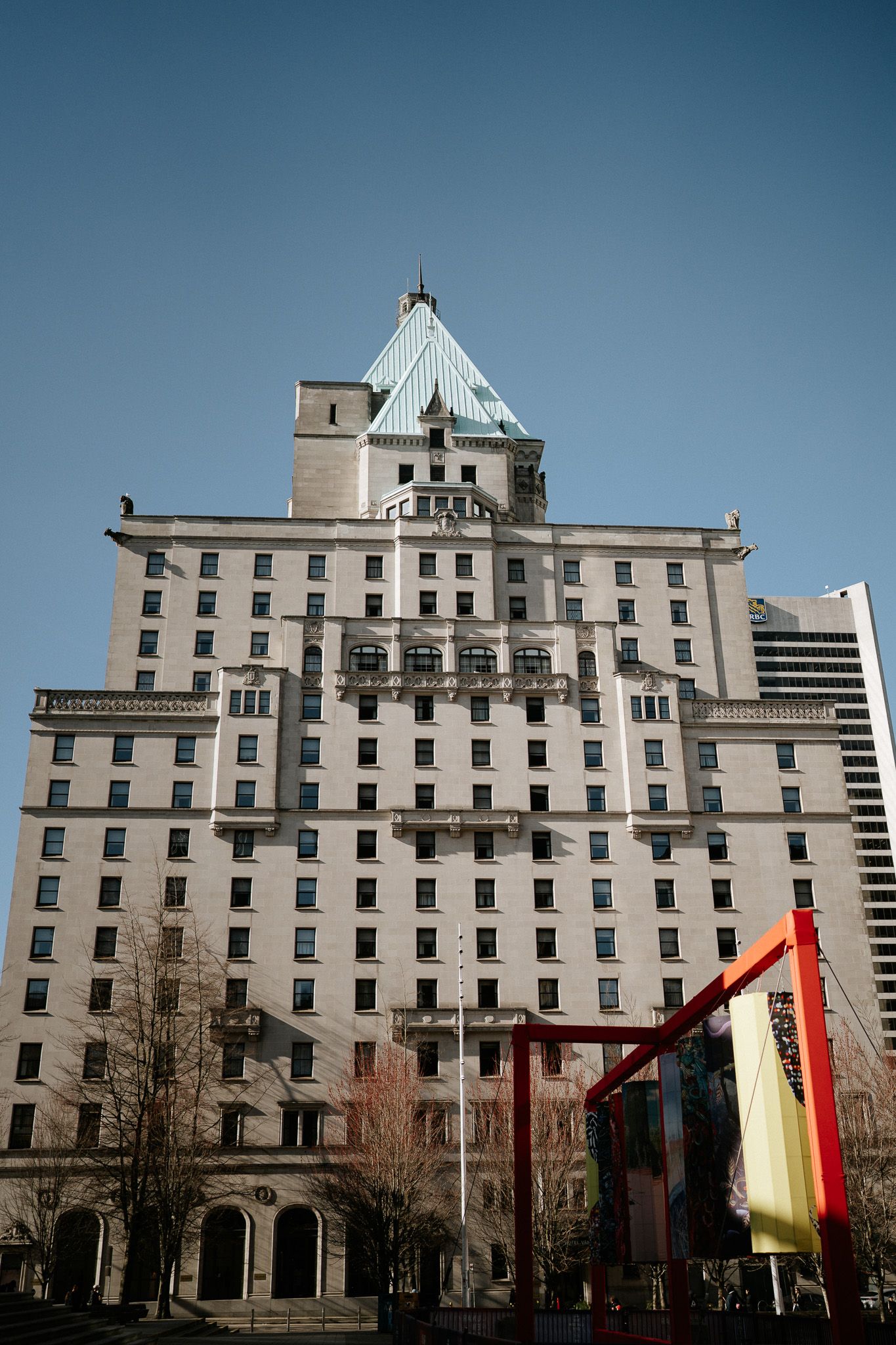 Historic hotel building with multiple windows and architectural details shown from different angles against a blue sky.
